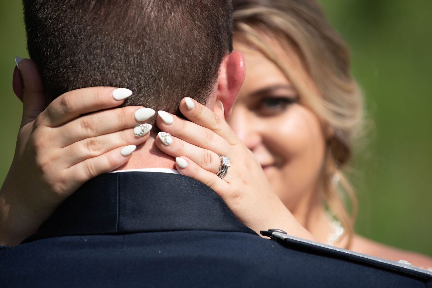 Close-up shot of embracing couple during outdoor wedding ceremony. Zimmerman MN Weddings