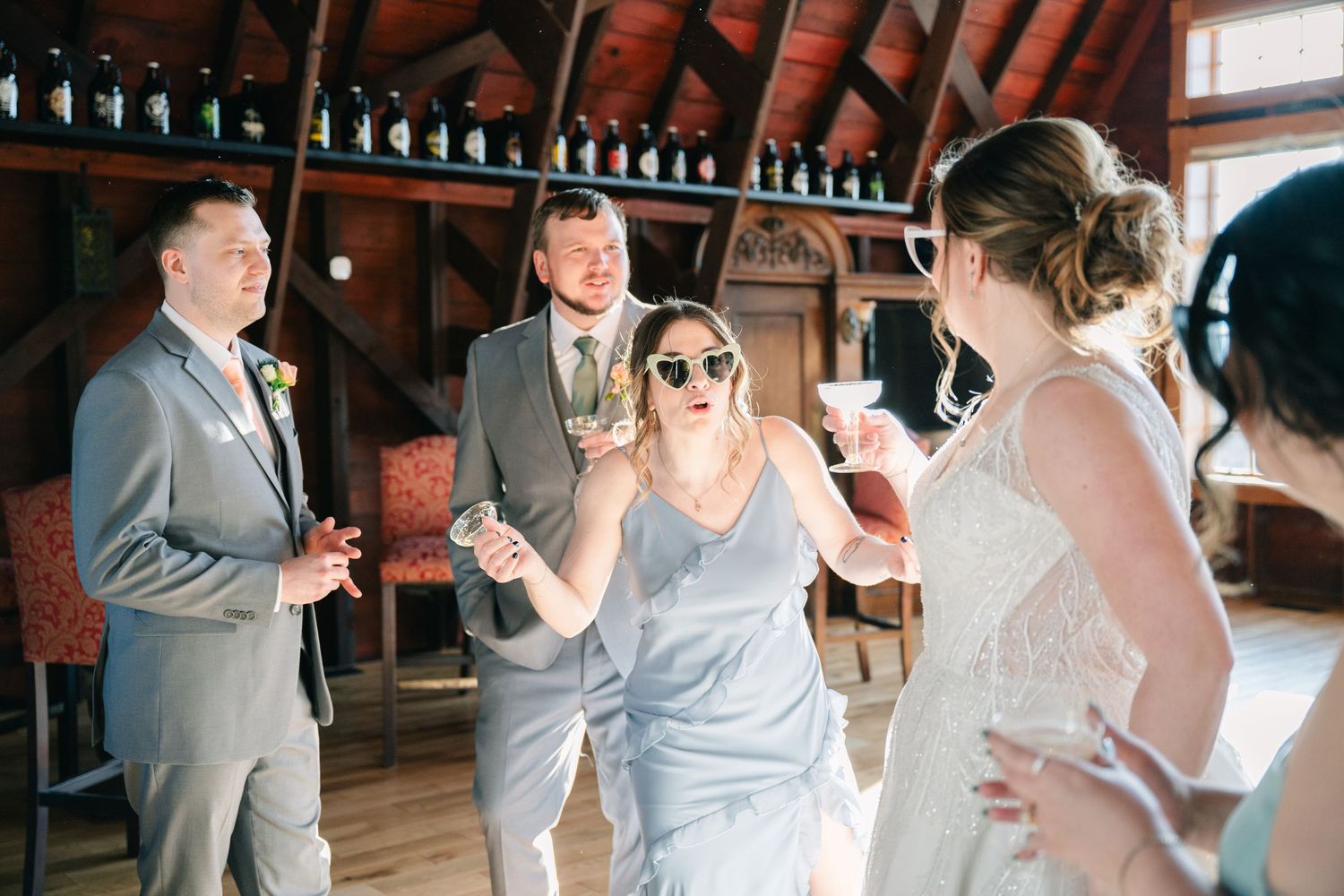 Wedding guests laughing and celebrating together at rustic indoor reception venue.
