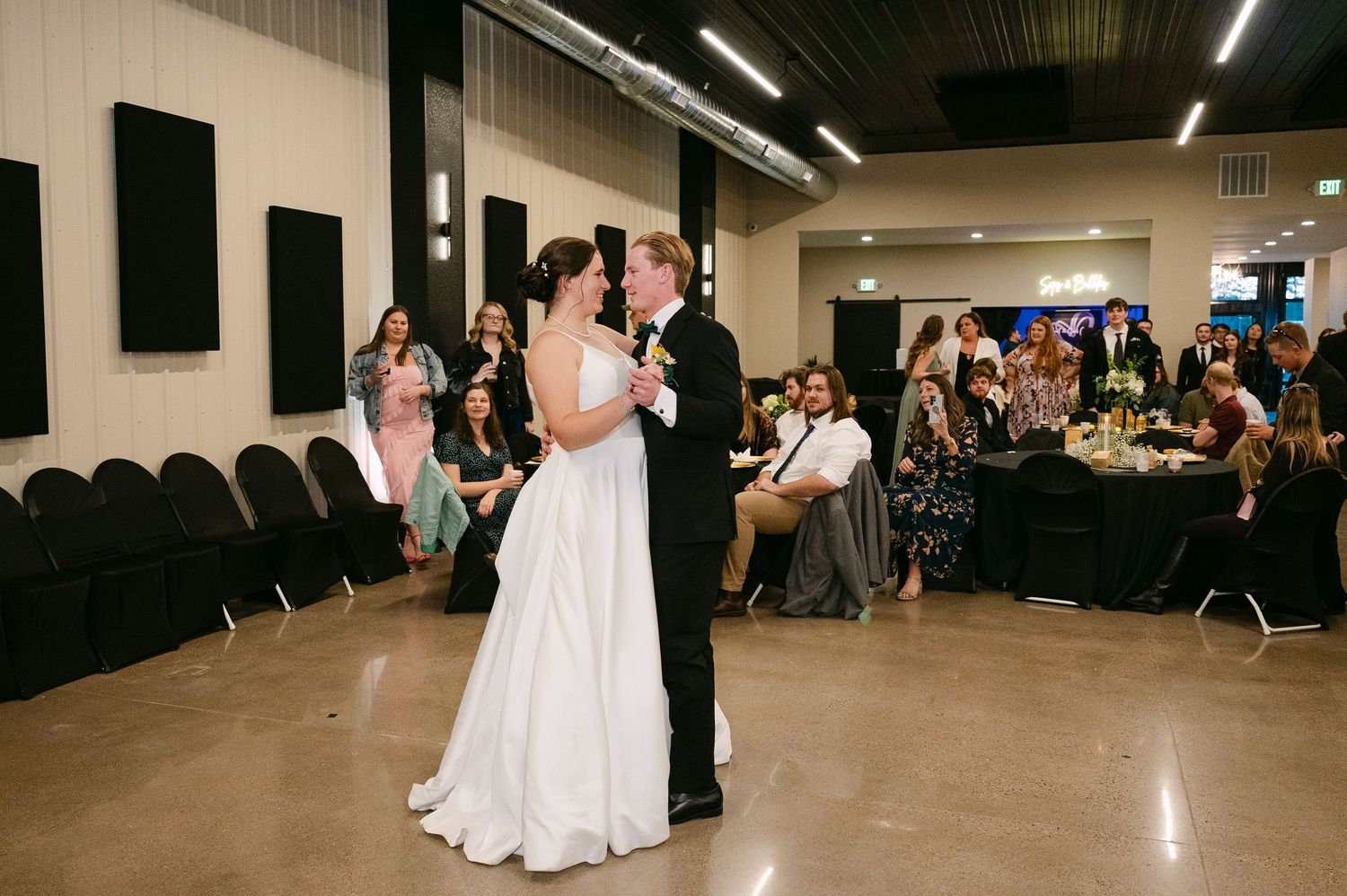 Wide angle view of wedding reception venue with dance floor and guest seating.