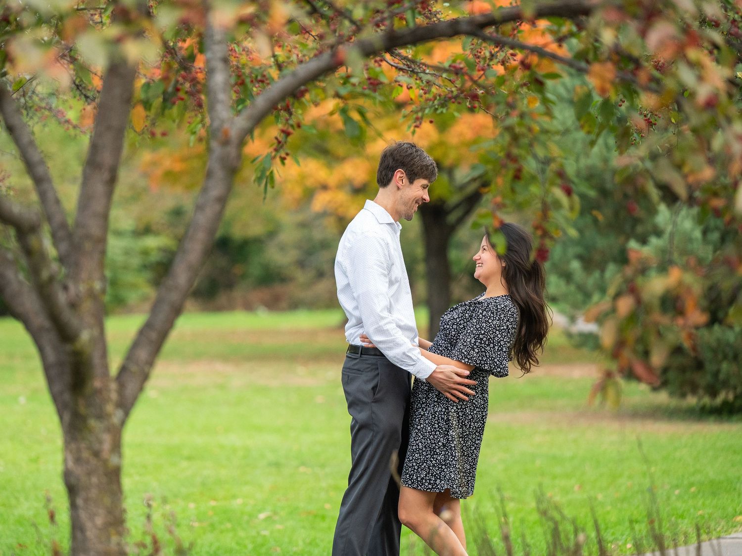 A couple shares an intimate moment surrounded by autumn trees in a park setting during a romantic photoshoot at Lake Como. Engagement Sesh.