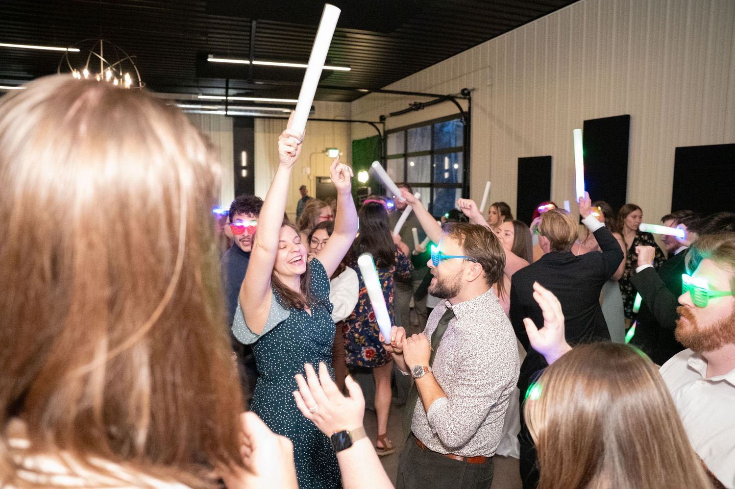 People dancing and celebrating at a lively party or event with hands raised in the air.