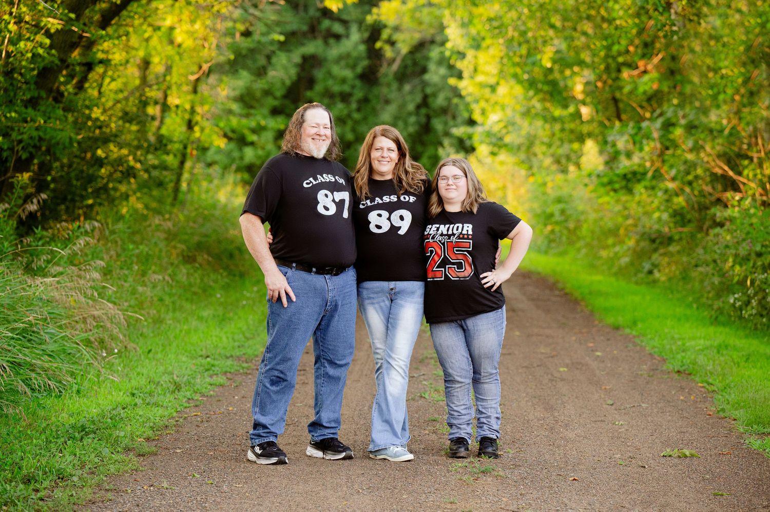 Group stands together on a grassy dirt path surrounded by lush green foliage and autumn colors.