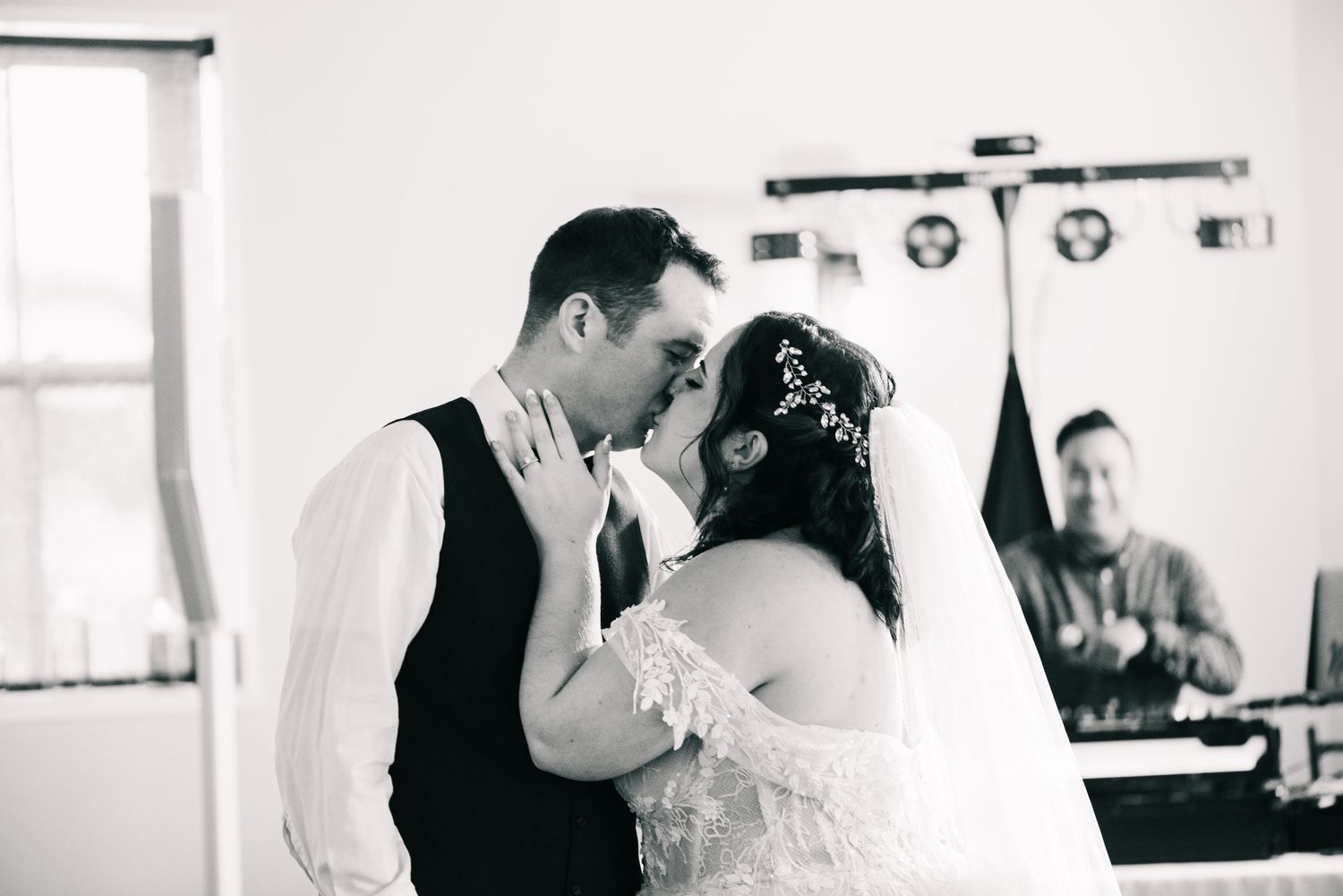 Central MN Wedding Photos - Black and white photo of a bride and groom sharing their first kiss at the wedding altar.