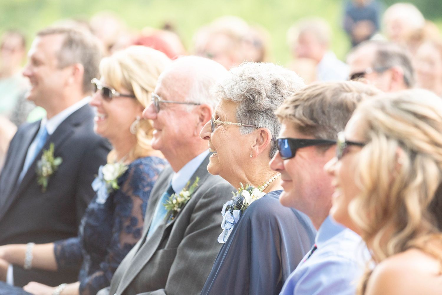 Wedding attendees watching ceremony from rows of white chairs in an outdoor garden setting. Zimmerman MN Weddings