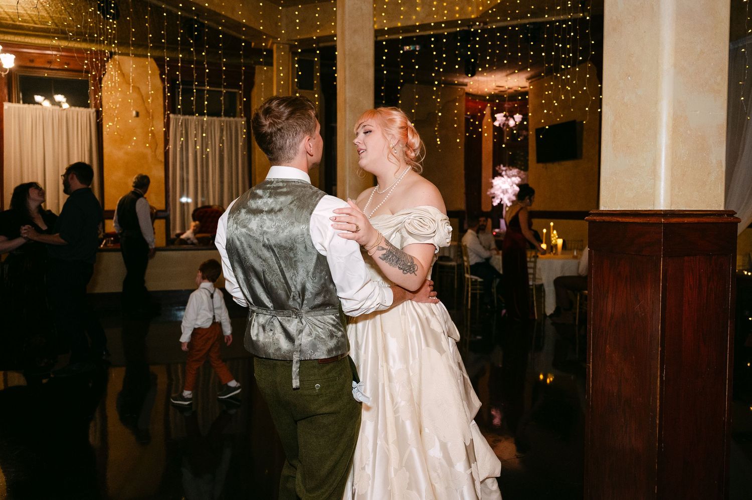 Central MN Wedding Photos | Bride and groom share first dance under sparkling lights at wedding reception.