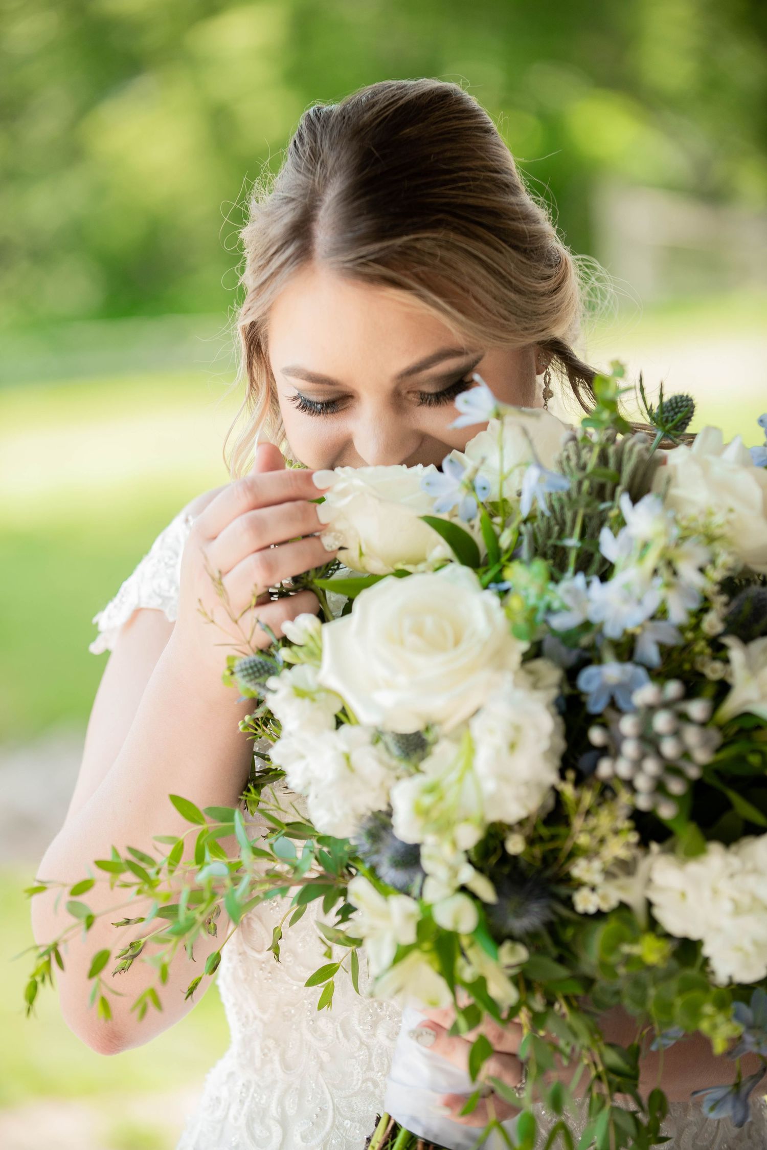 A bridal bouquet of white roses and greenery with soft natural lighting. Zimmerman MN Weddings