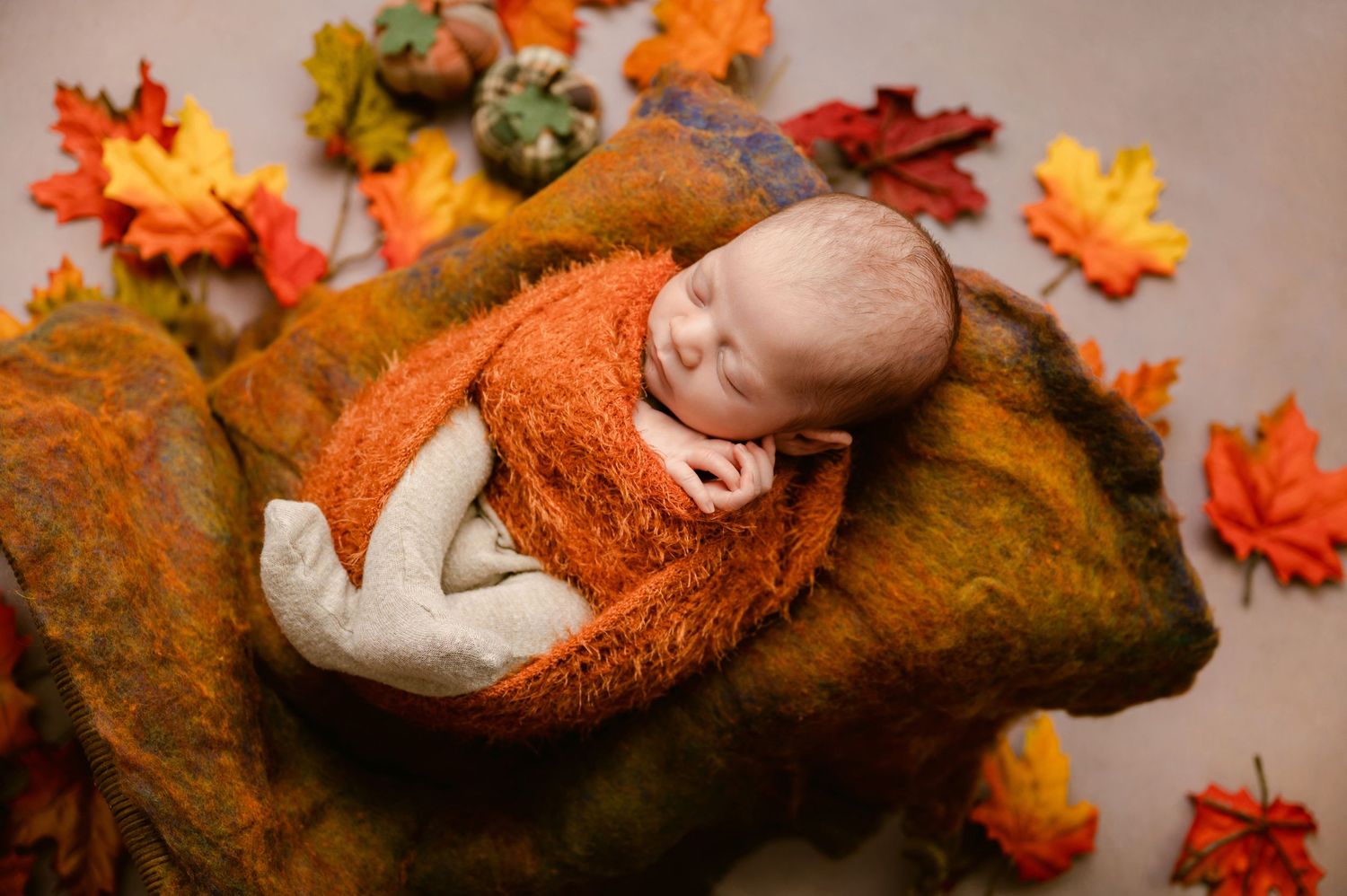 Autumn newborn photography setup with orange and brown blankets, leaves, and fall decorations arranged in a cozy collage.