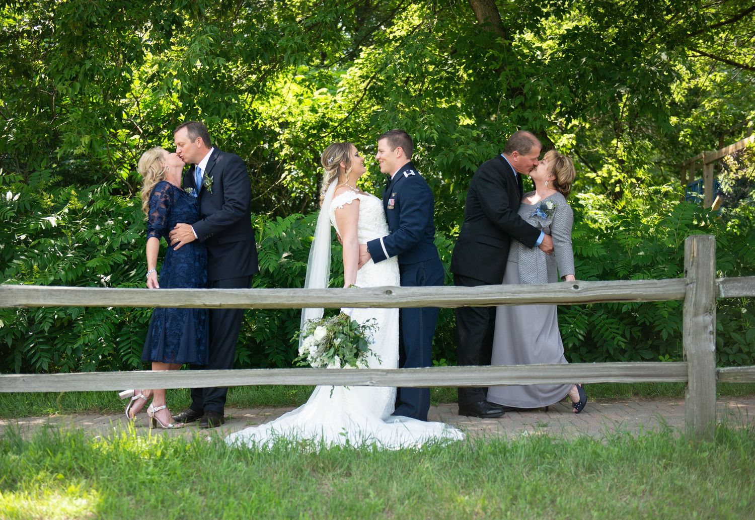 Wedding party gathered on a wooden walkway surrounded by greenery. Zimmerman MN Weddings