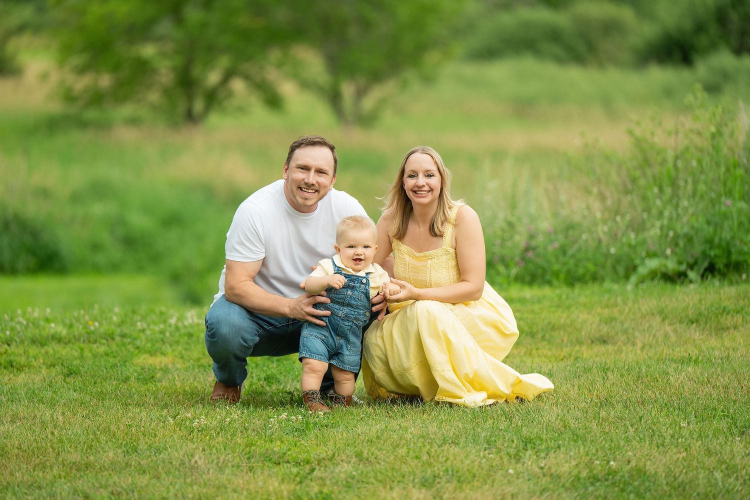 A series of photos showing a family lying together on green grass, with someone wearing a yellow dress. Family Portraits & Milestone Moments