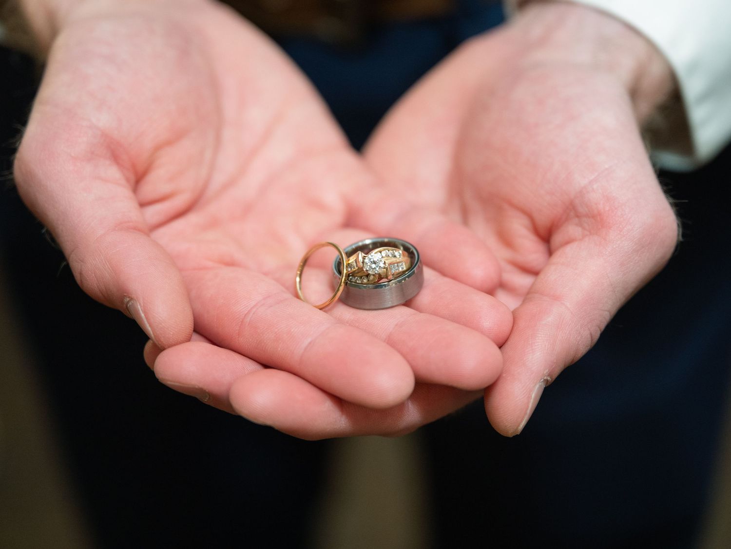 Close up view of hands holding wedding rings during a ceremony at Northern Lights near Milaca MN..