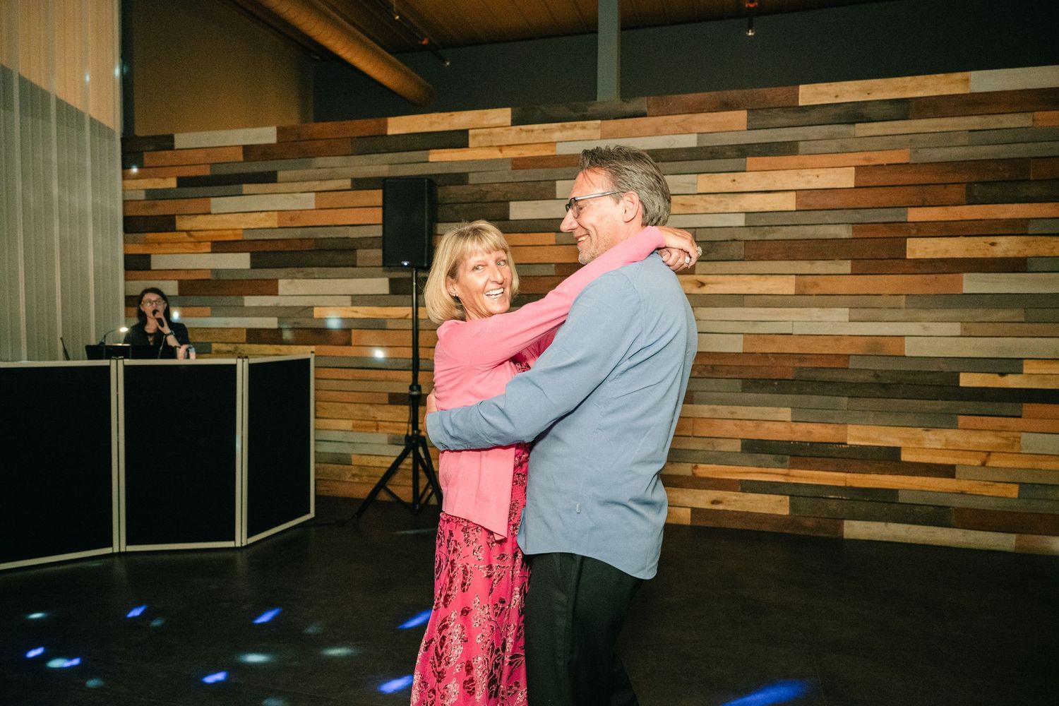 Couple sharing a romantic dance on illuminated dance floor at wedding reception venue.