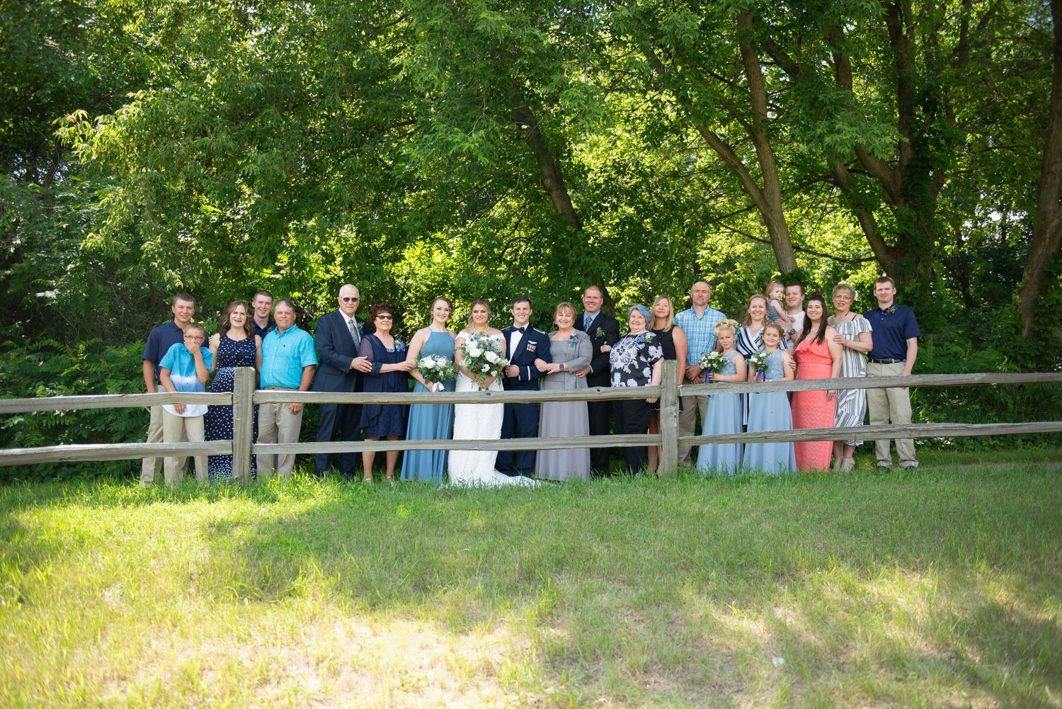 Wedding guests gathered on a hillside watching outdoor ceremony. Zimmerman MN Weddings