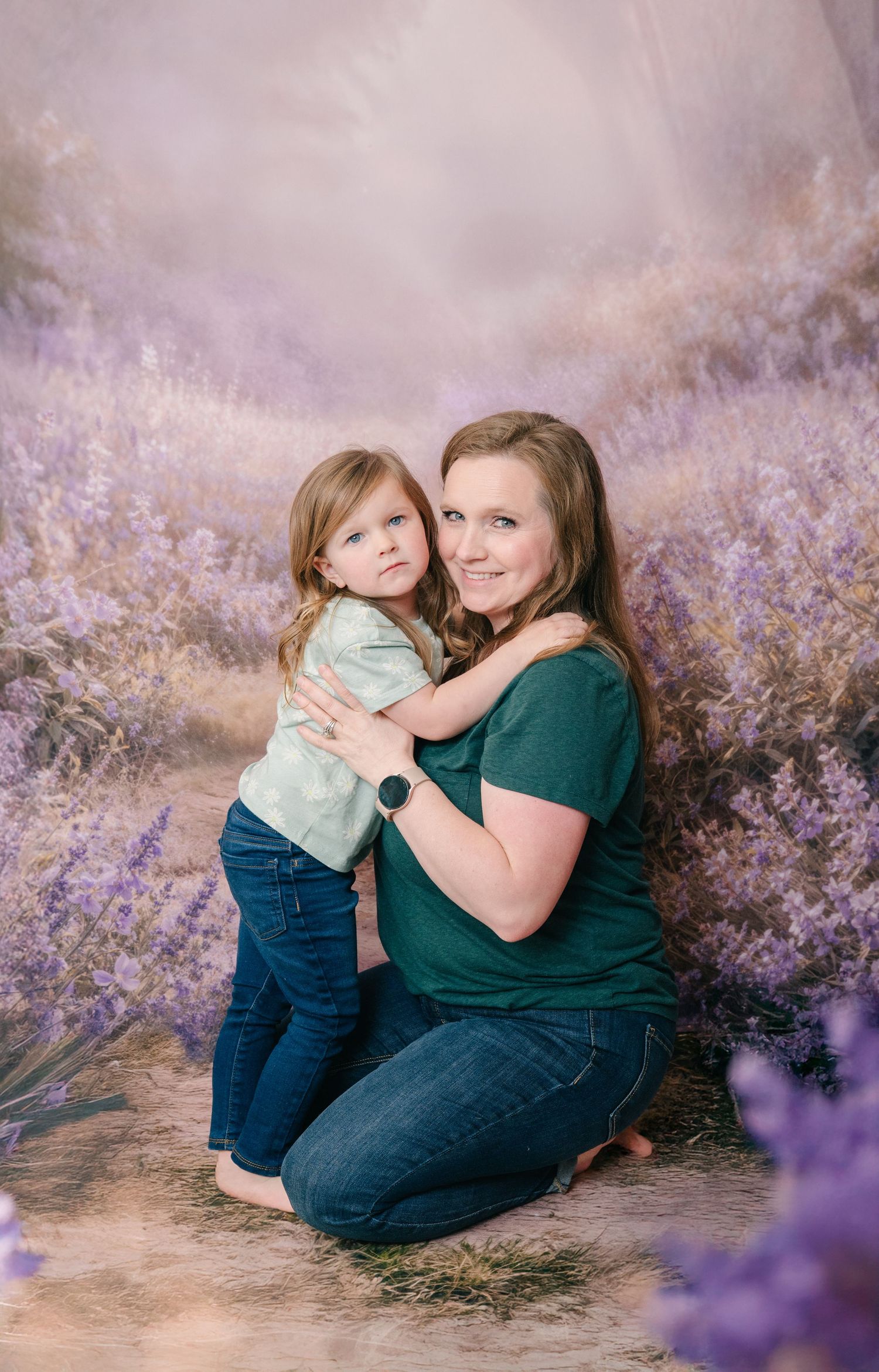Central MN Motherhood Photos - A mother in a green shirt kneels hugging her young daughter in a lavender field portrait studio setting.