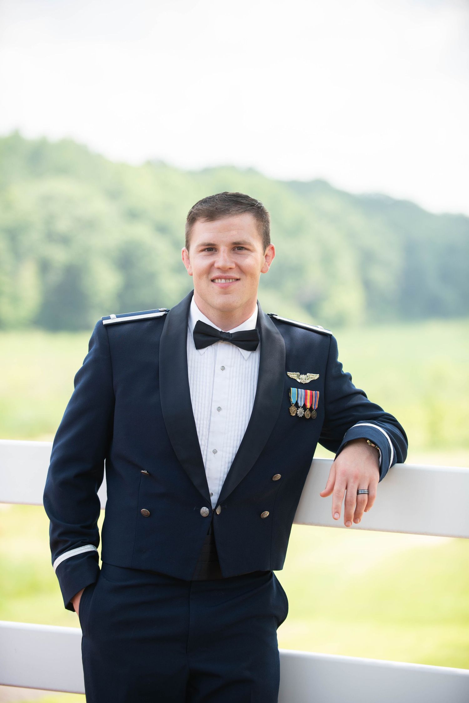 Military service member in dress uniform poses outdoors at wedding venue. Zimmerman MN Weddings