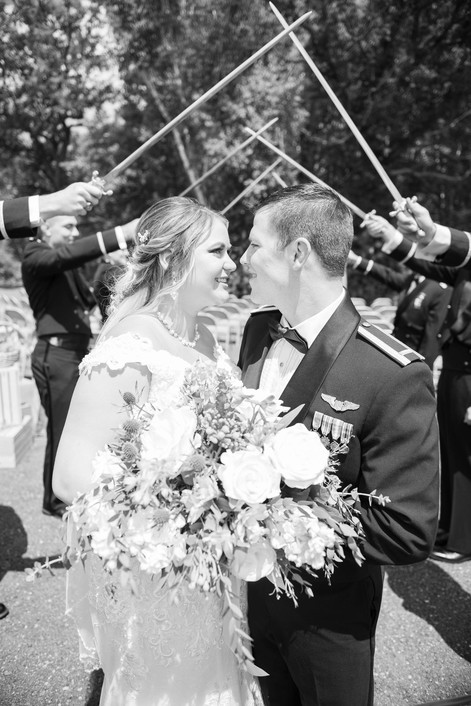 Military members perform a traditional sword arch ceremony at an outdoor wedding. Zimmerman MN Weddings