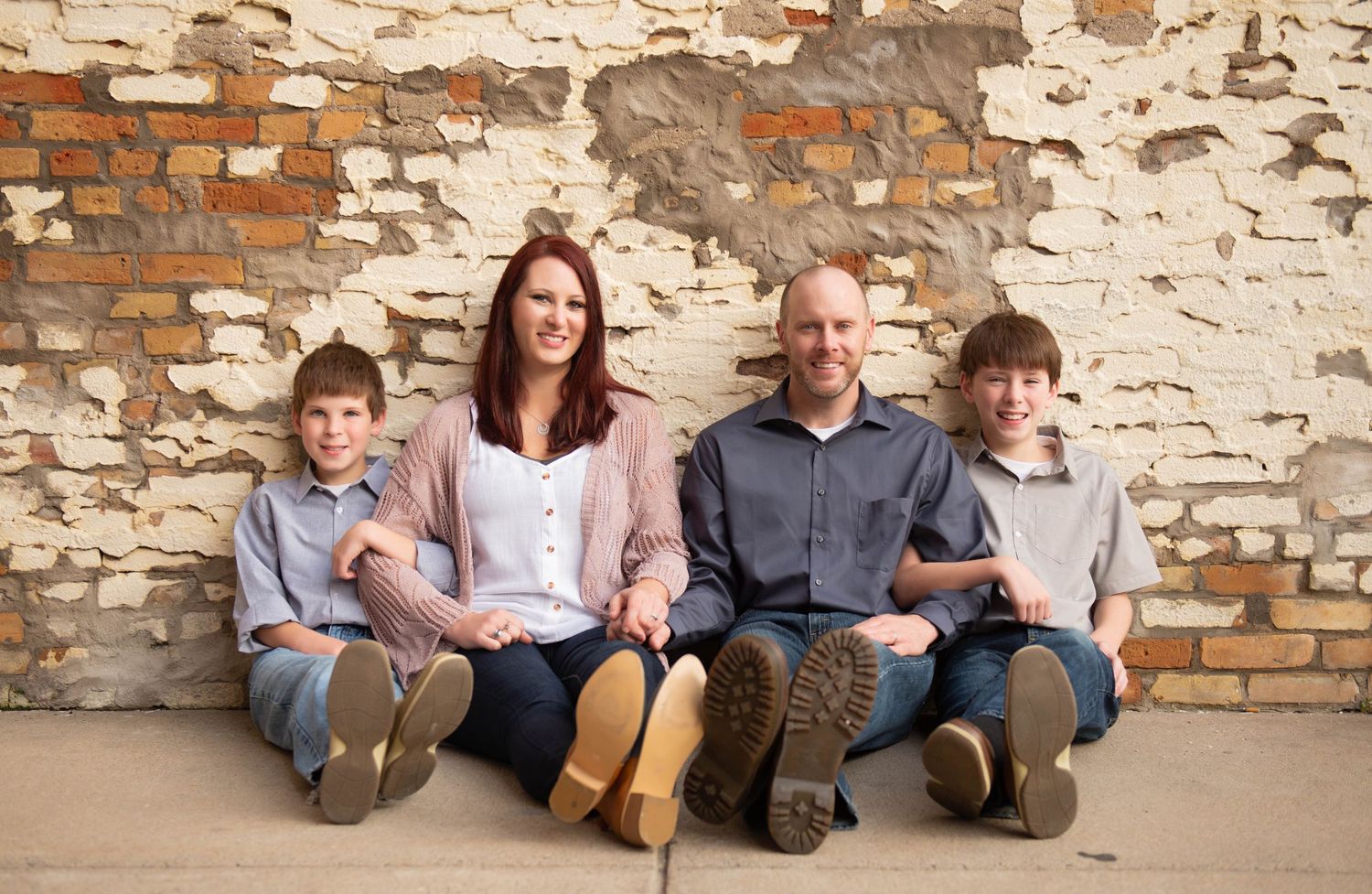 A series of relaxed poses against a weathered brick wall showing casual interactions.