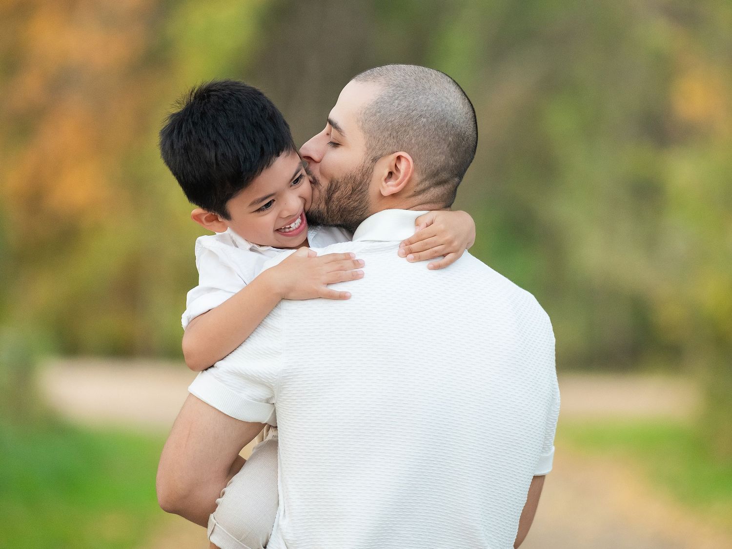 Couple shares intimate moments in a natural outdoor setting with soft lighting.
