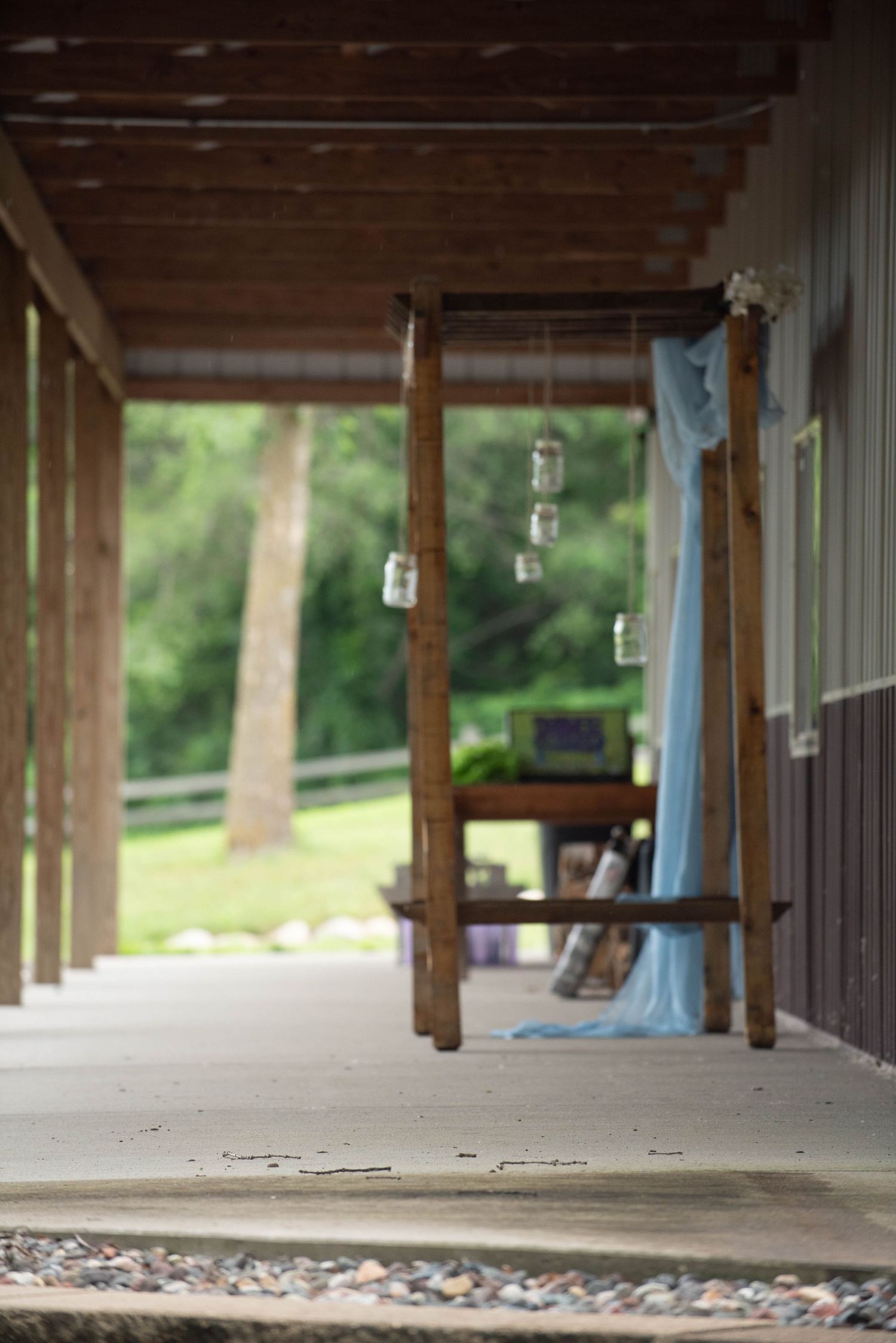 Rustic wooden pavilion decorated with hanging lanterns and blue accents for outdoor wedding venue. Zimmerman MN Weddings