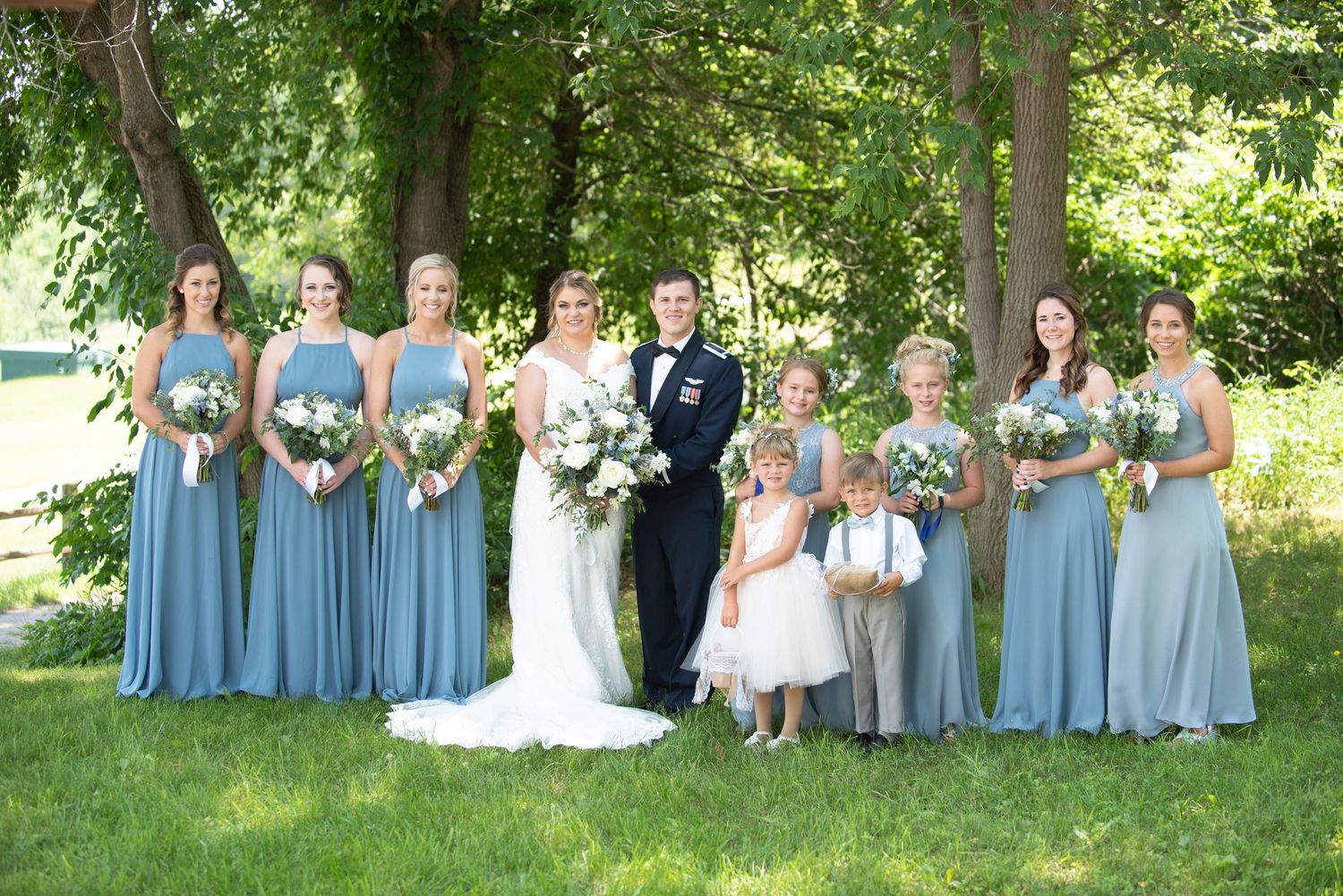 Wedding party in light blue bridesmaid dresses posed outdoors in natural setting. Zimmerman MN Weddings
