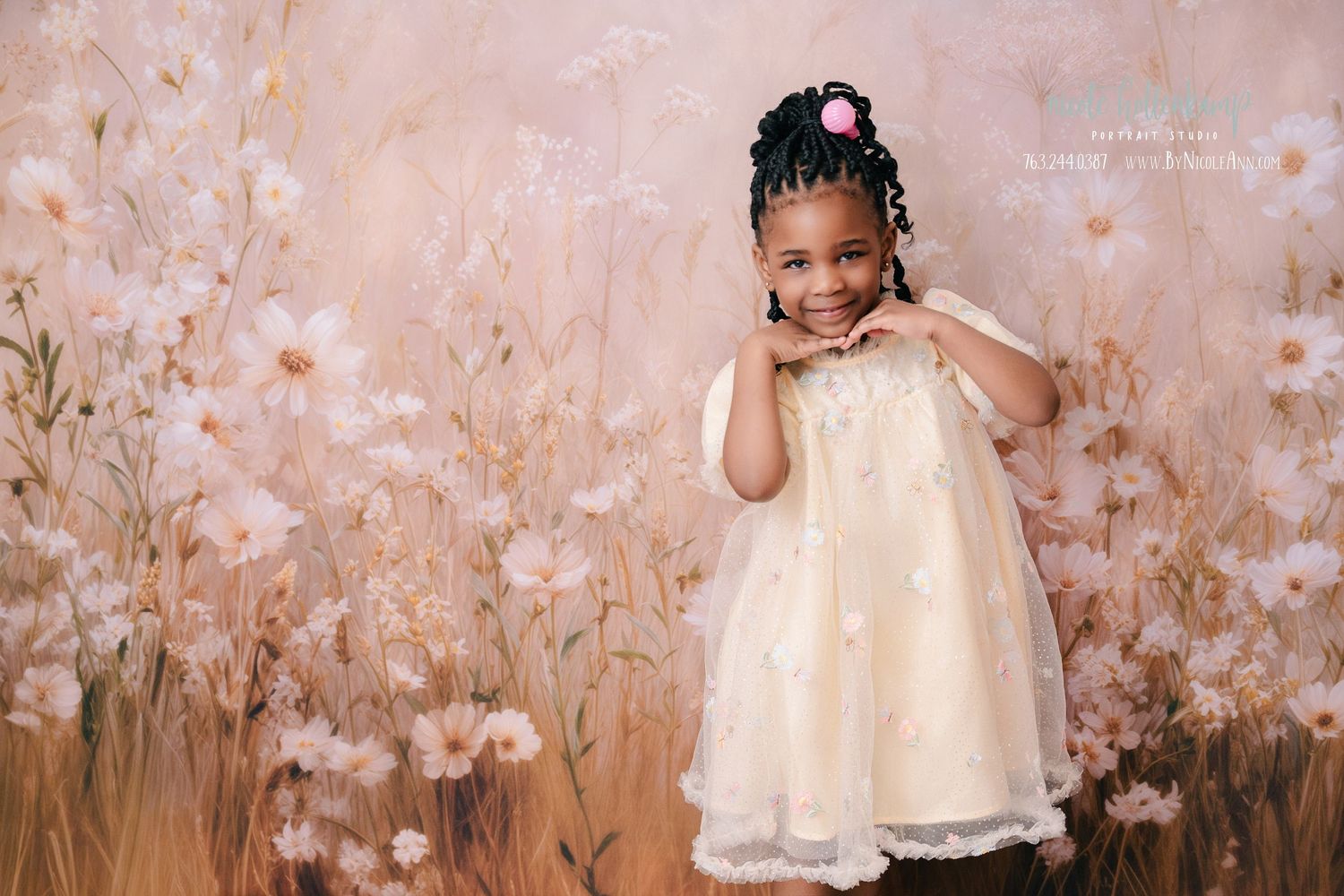 Young girl in white floral dress posing gracefully in front of a soft pink wildflower backdrop. mother day photoshoot
