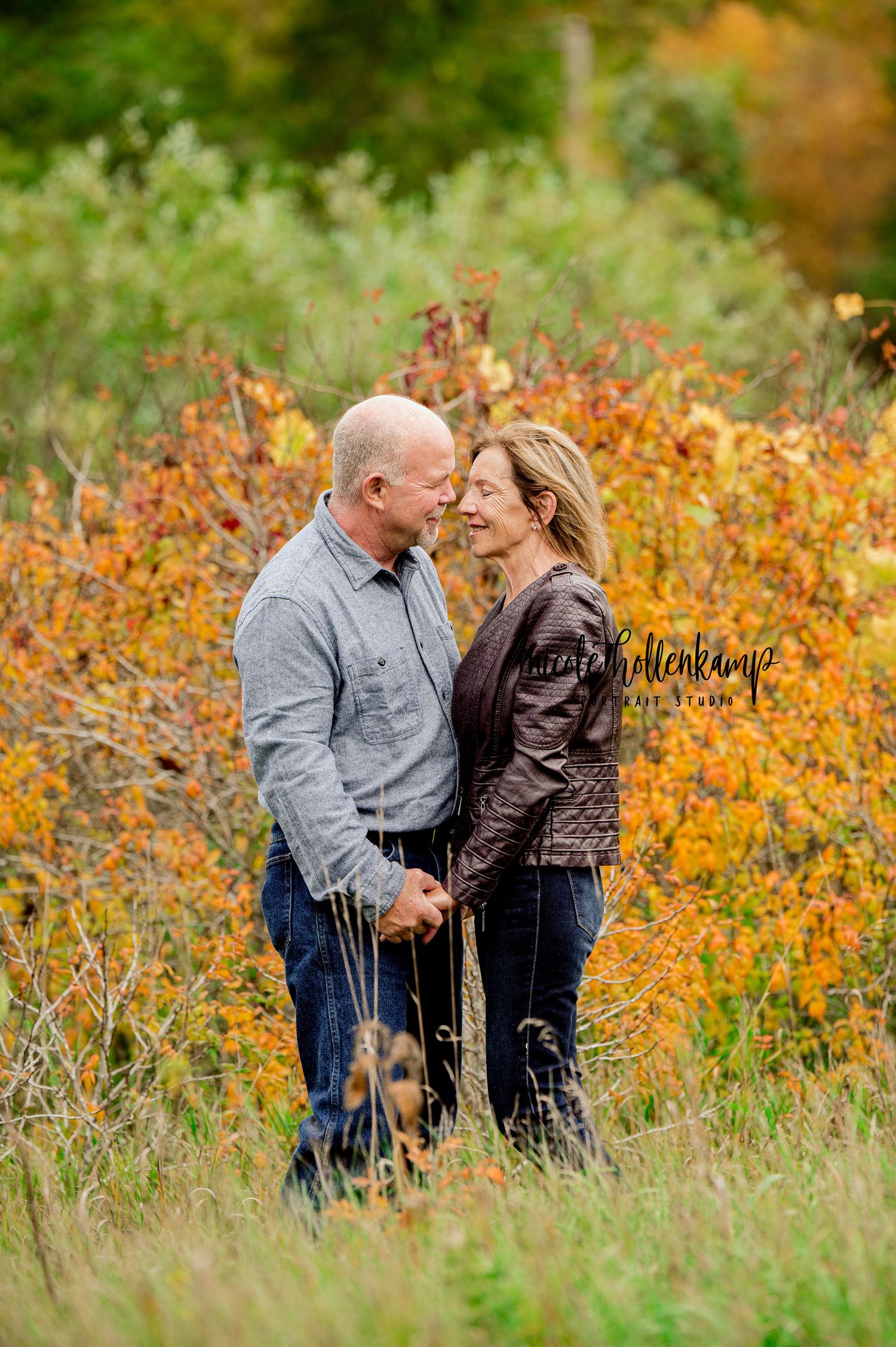 Couple shares intimate moment in field of vibrant autumn wildflowers.