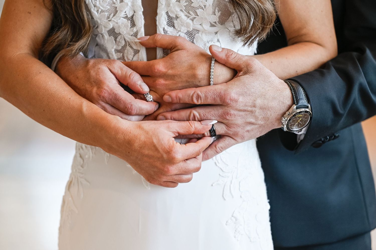 Detail shot of couple's hands during intimate wedding moment.