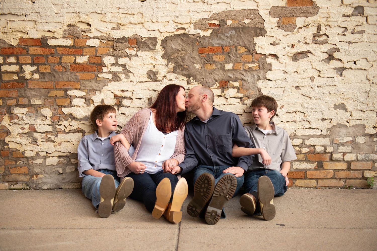 A sequence of candid shots showing people sitting casually against a rustic brick wall.