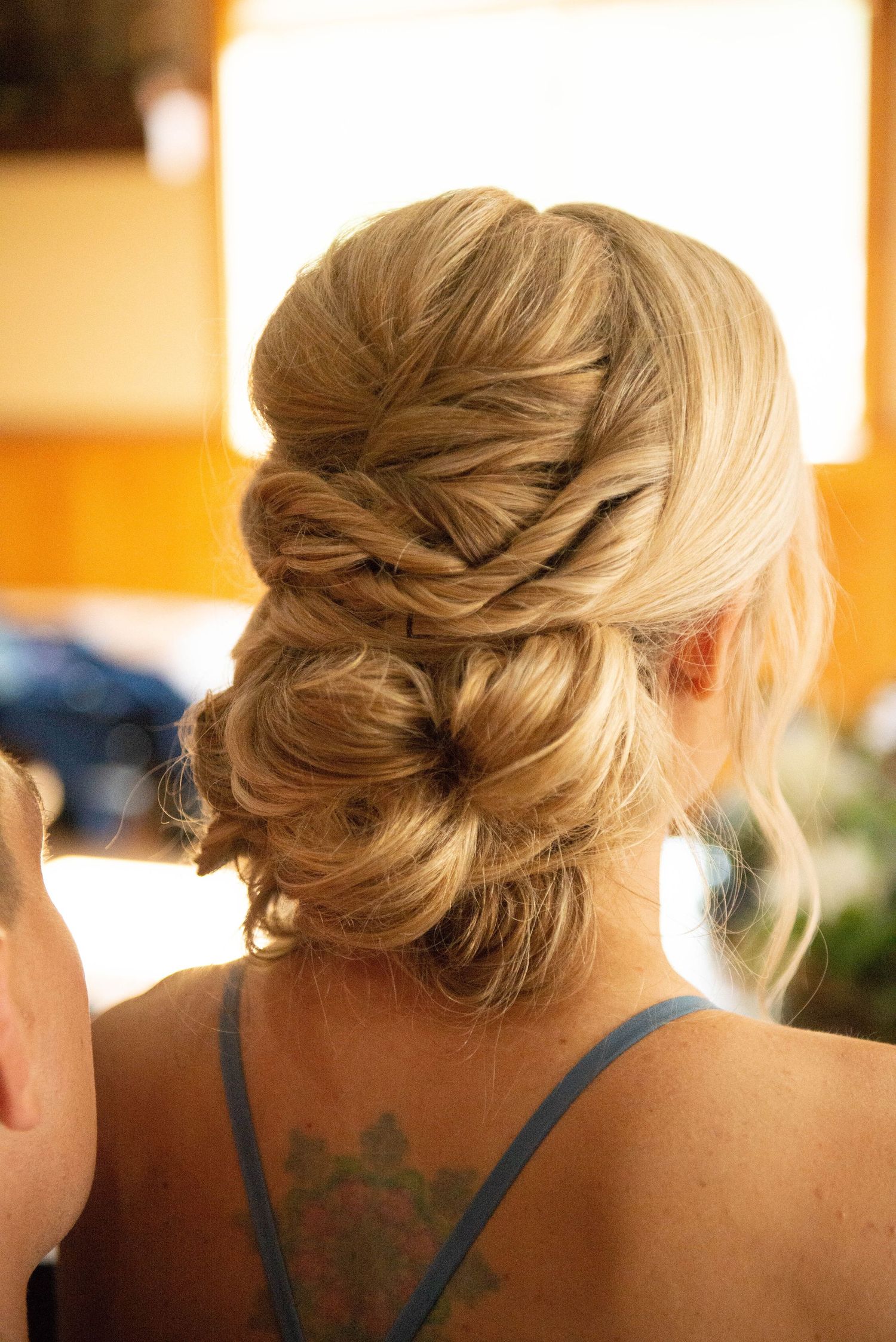 Row of elegant upswept hairstyles with braided details shown from behind. Zimmerman MN Weddings