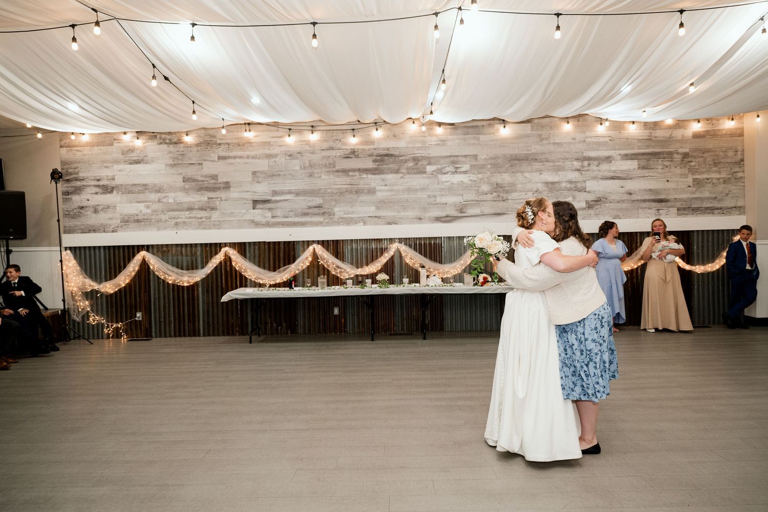A beautiful dance taking place in an elegant reception hall with wood-paneled walls and draped decorations.