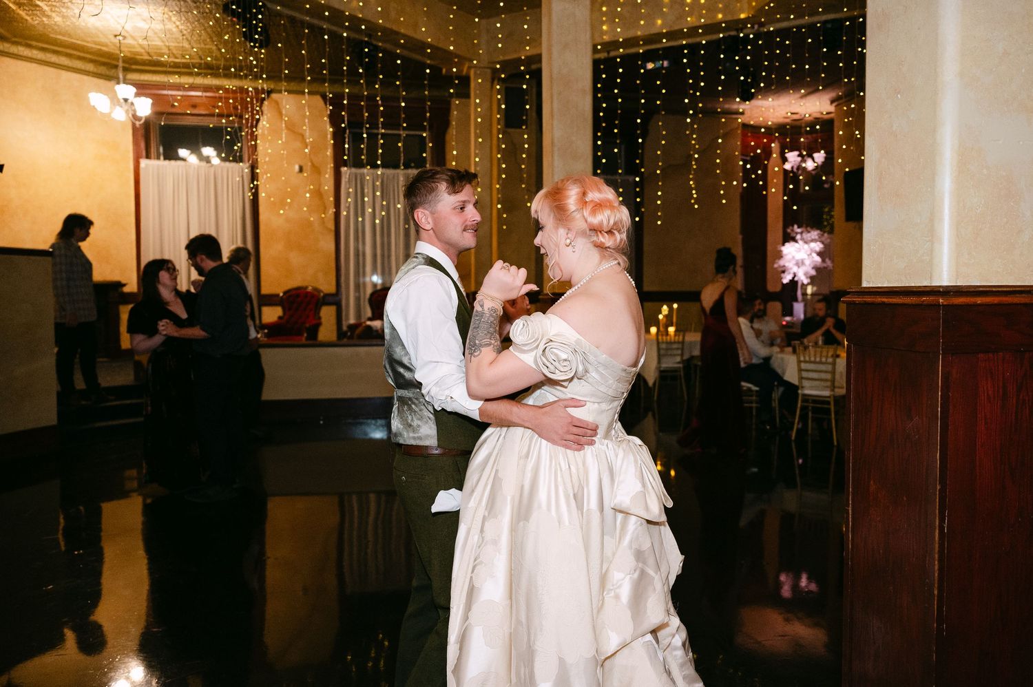 Central MN Wedding Photos | Bride and groom sharing romantic first dance under twinkling string lights.