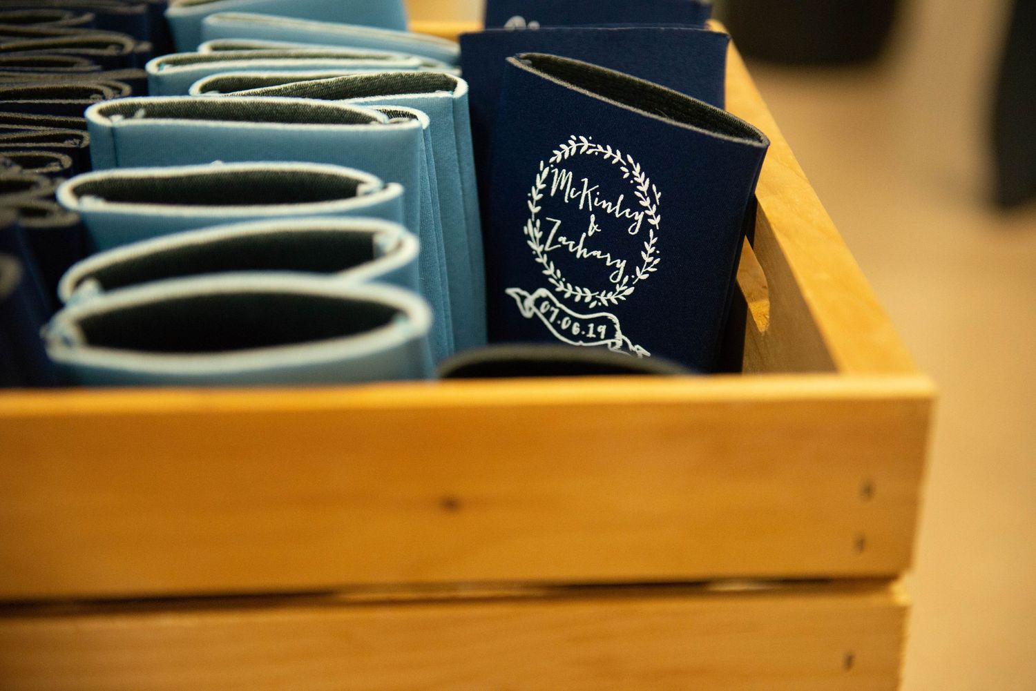 Navy blue branded passport covers and travel documents arranged in a wooden organizer box. Zimmerman MN Weddings