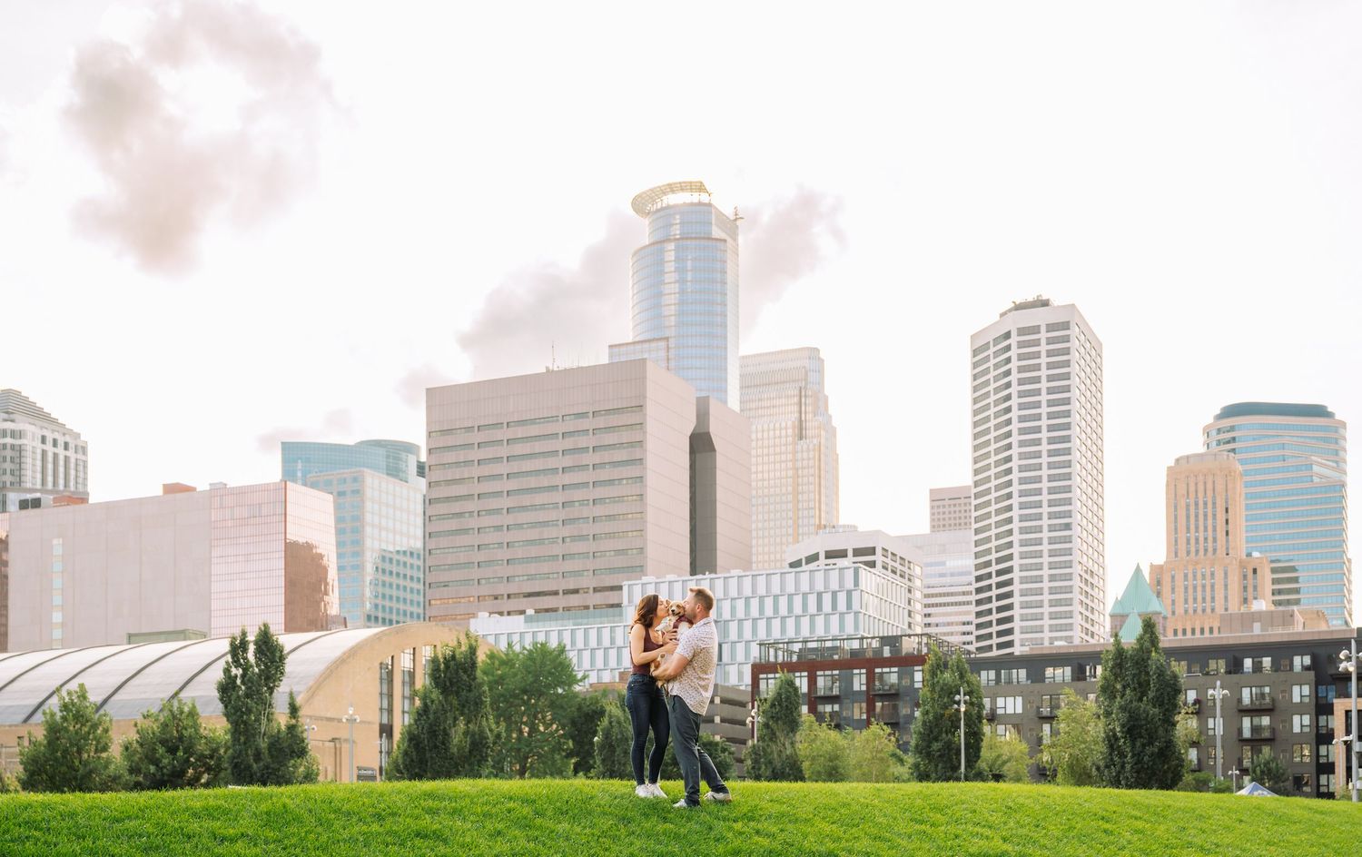 A city skyline stretches across the horizon with green grass in the foreground.