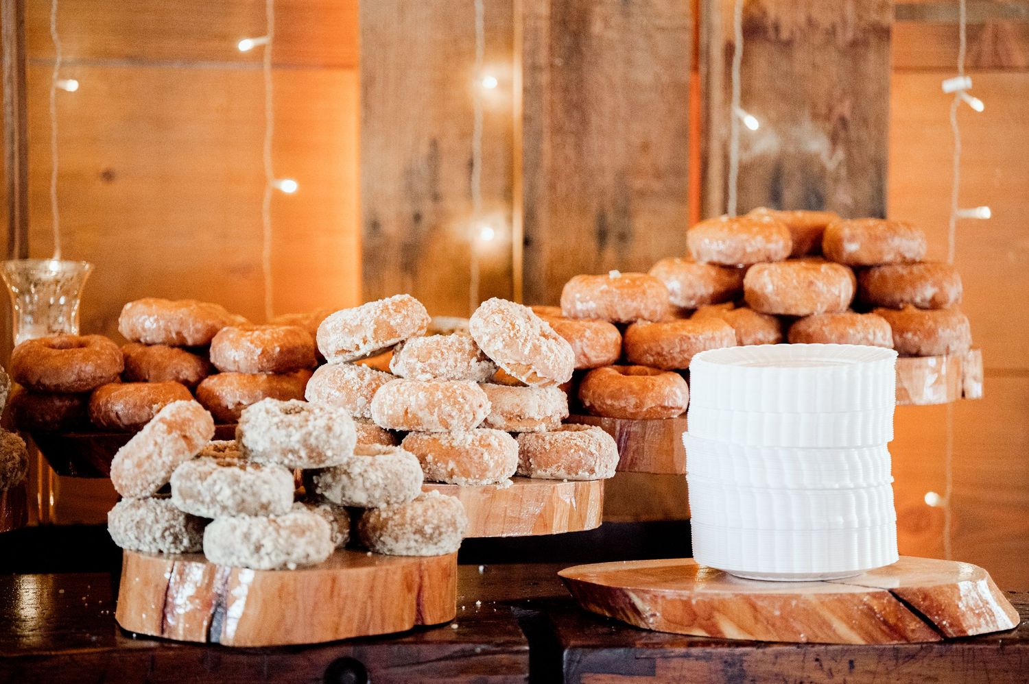 Rustic wooden slices arranged as wedding reception decor with warm lighting.