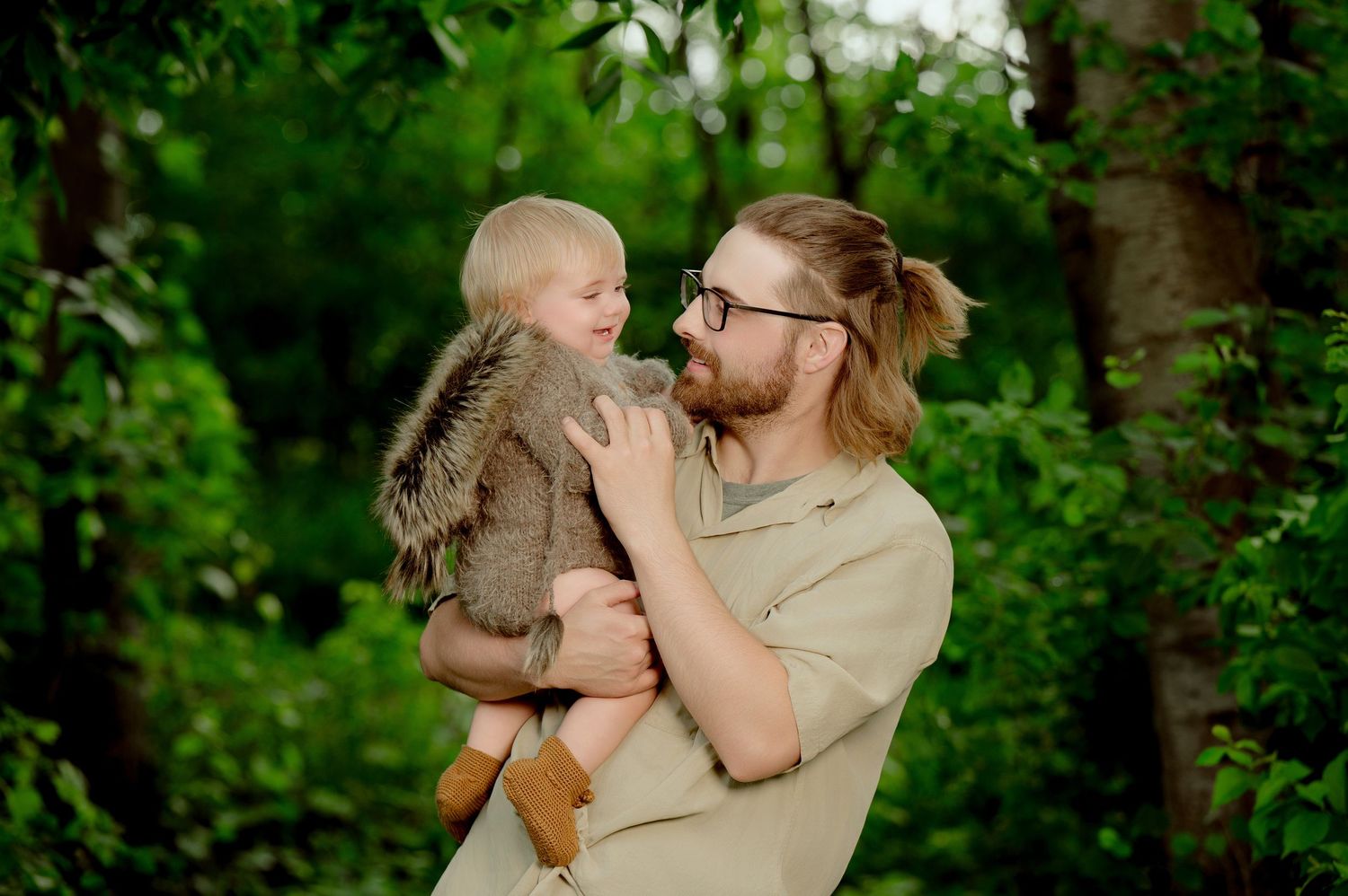 A tender embrace between two people joyfully spinning in a lush green forest setting. Princeton MN Milestone, Maternity and Newborn P
