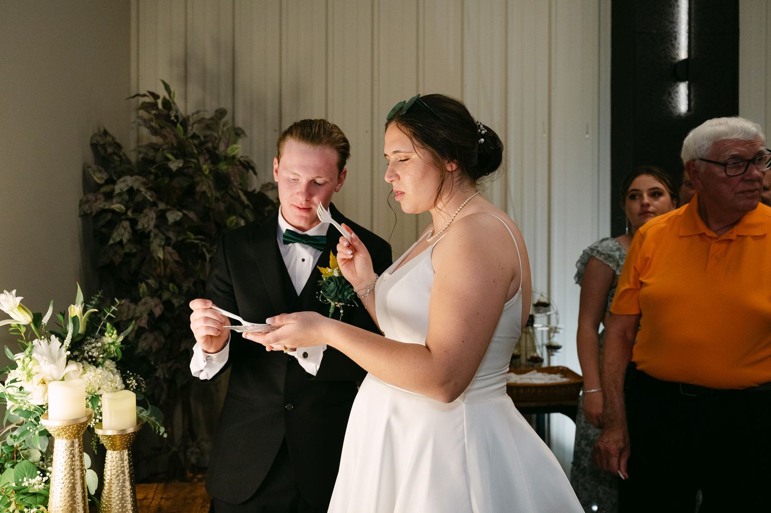 Wedding guests gather in an intimate indoor venue during a reception celebration.