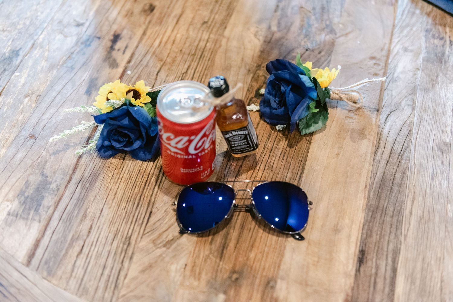 Central MN Wedding Photos | Wedding groomsmen accessories with blue roses, sunflowers, Coca-Cola, Jack Daniels, and aviator sunglasses.
