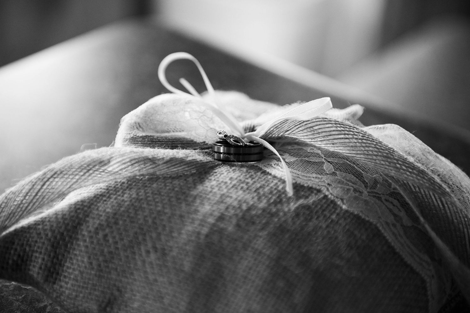 Close-up detail of white lace on a wedding dress against a dark background. Zimmerman MN Weddings