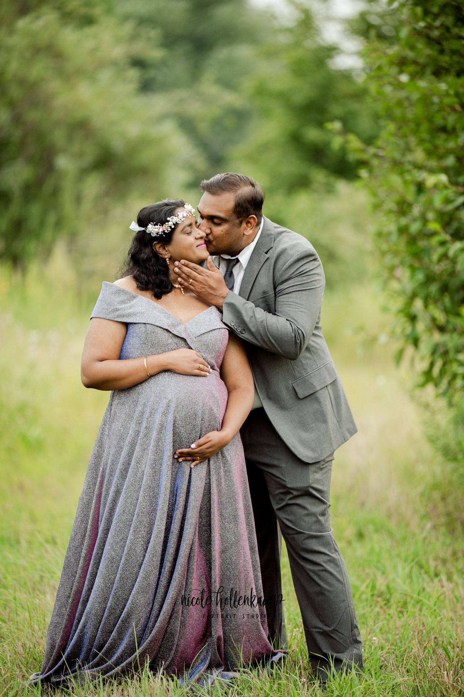 Romantic maternity portrait of couple in outdoor meadow setting.