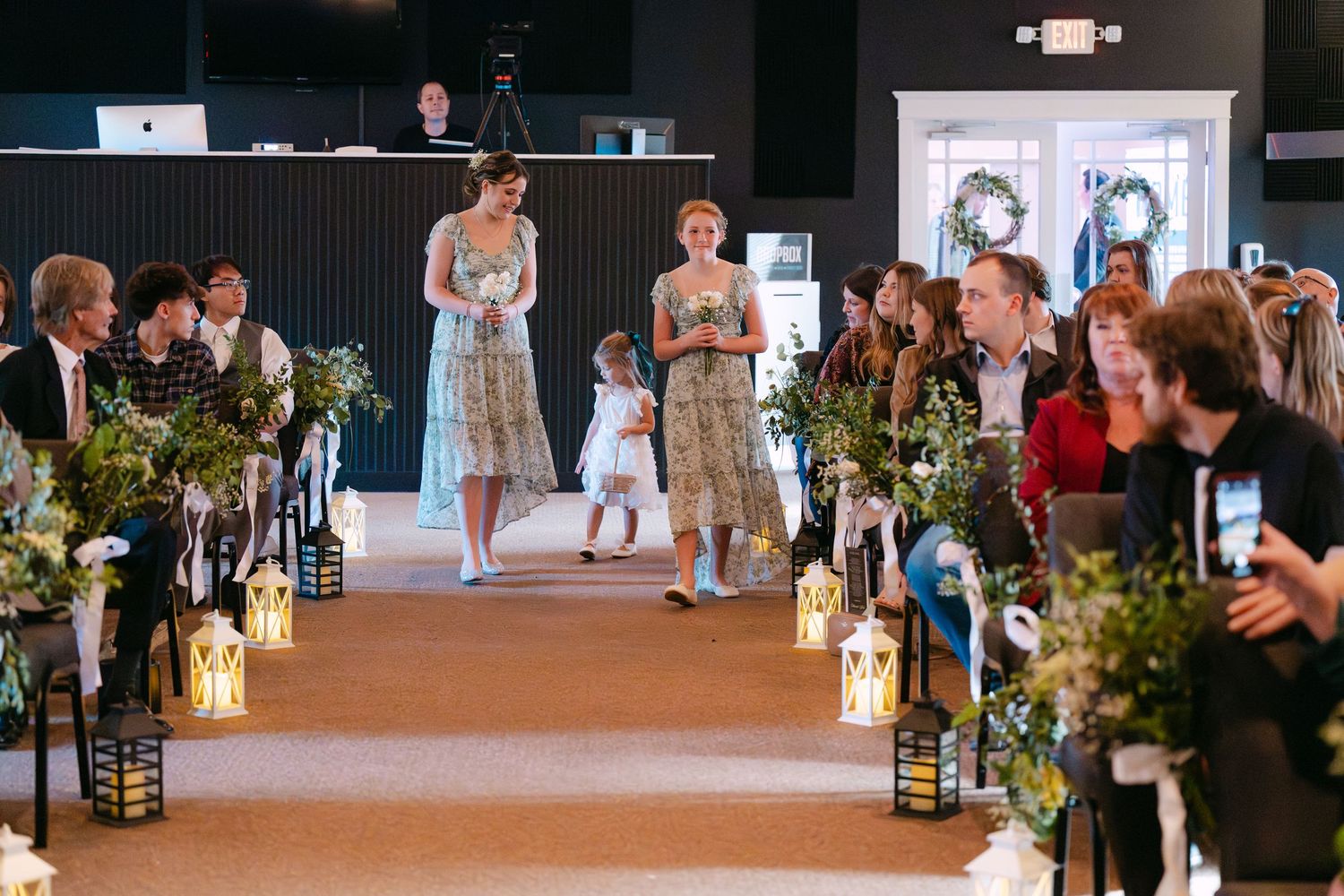 Wide view of wedding ceremony space with decorative lanterns lining the aisle.