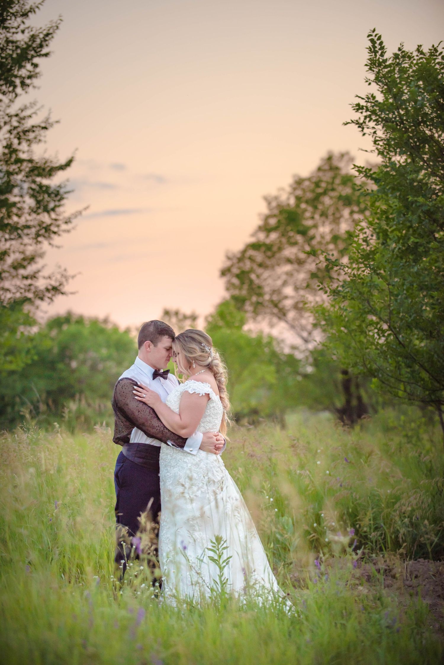 Romantic sunset wedding portrait in tall grass with soft pink sky. Zimmerman MN Weddings
