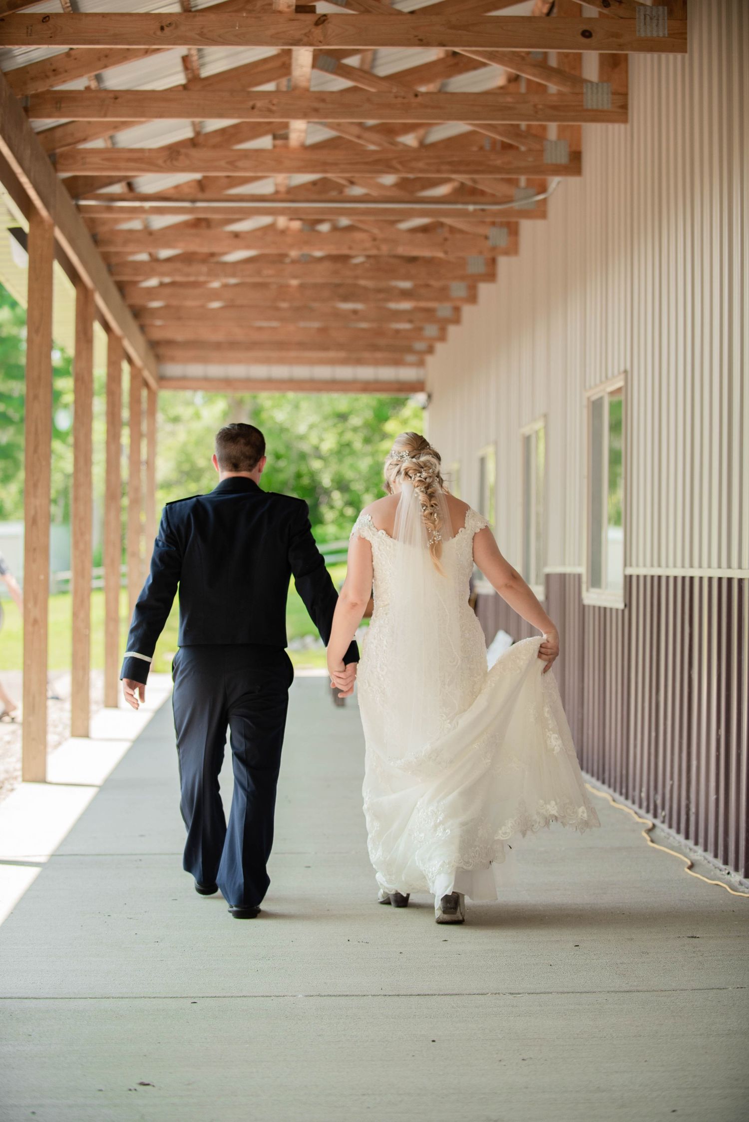 Wedding couple walking under a covered wooden walkway in sequence shots. Zimmerman MN Weddings
