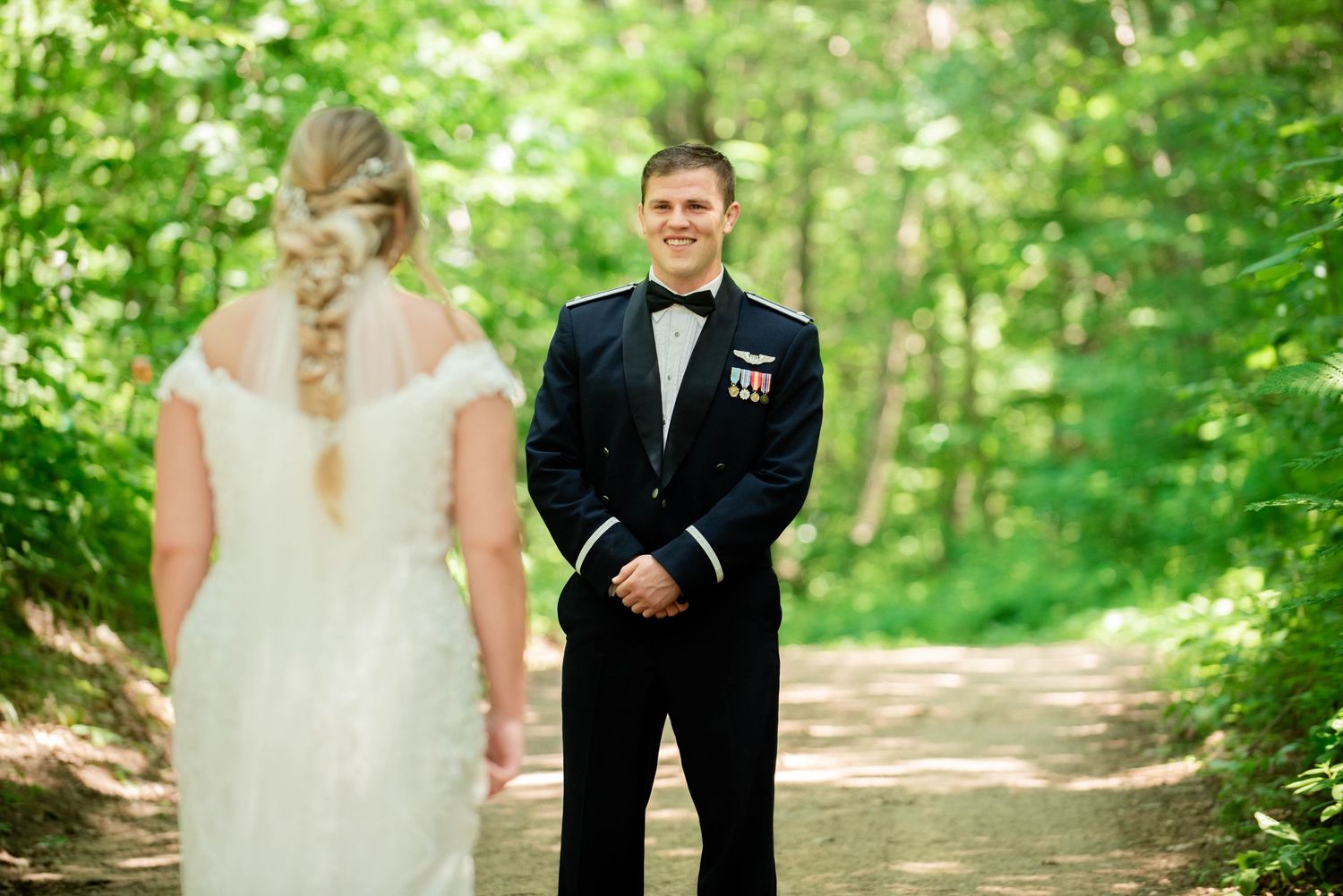 First look wedding moment captured on a wooded path with military groom and bride in lace dress. Zimmerman MN Weddings