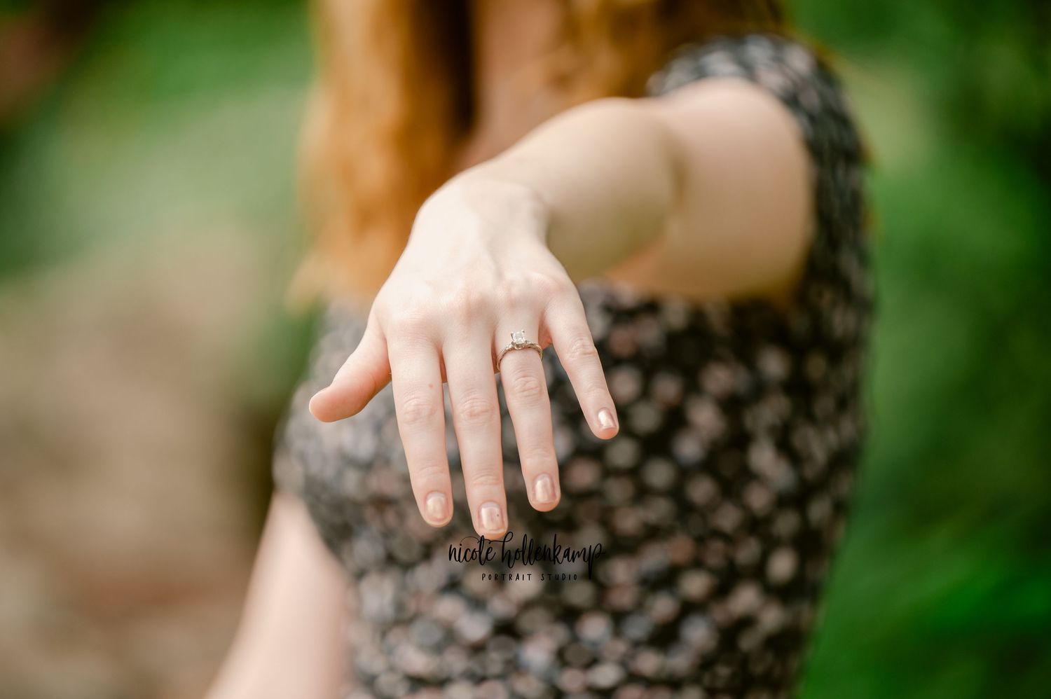 A person's hand delicately holds a baby hedgehog against a soft green blurred background.