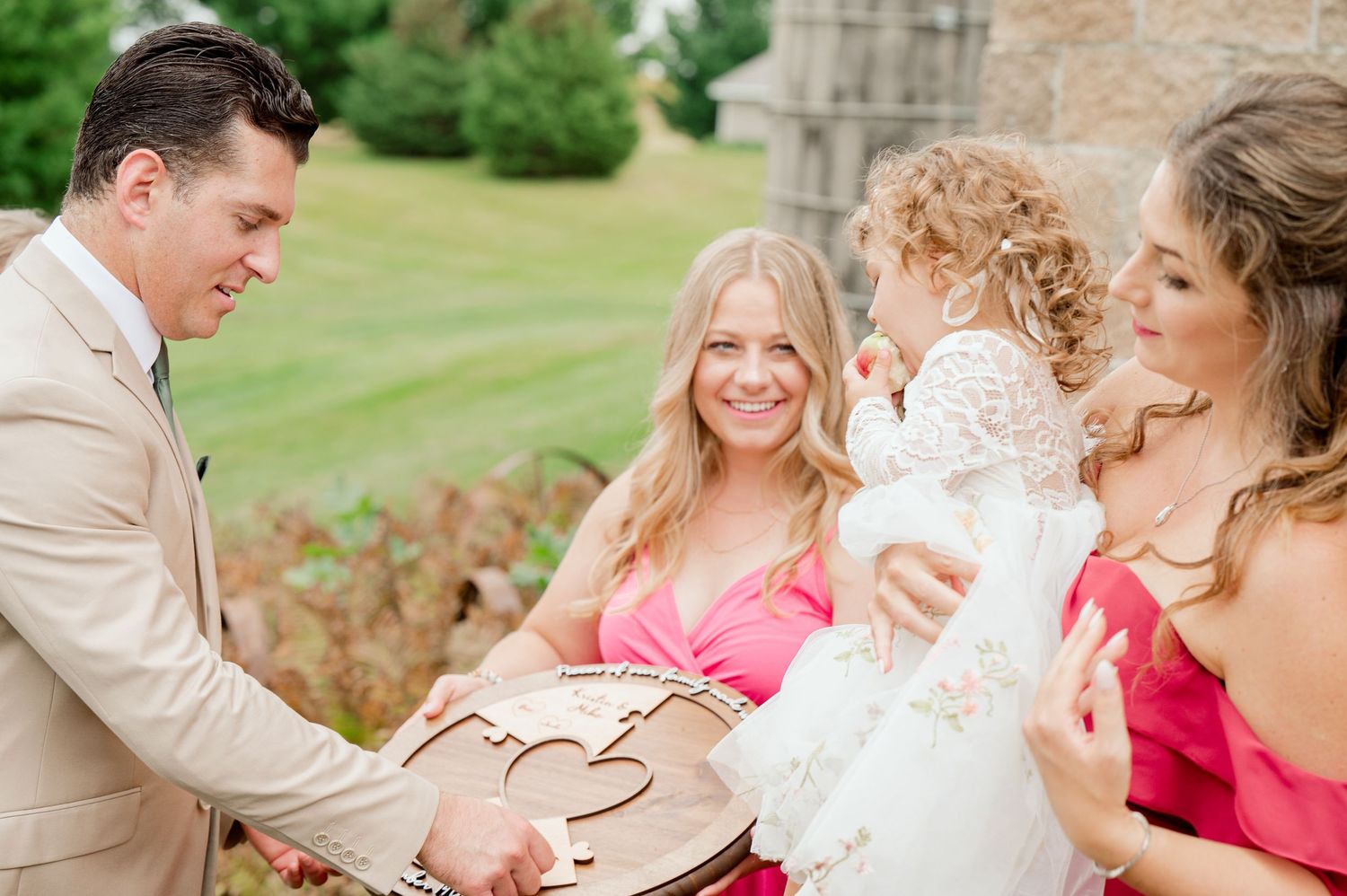 Candid moment shared between wedding guests during outdoor celebration.