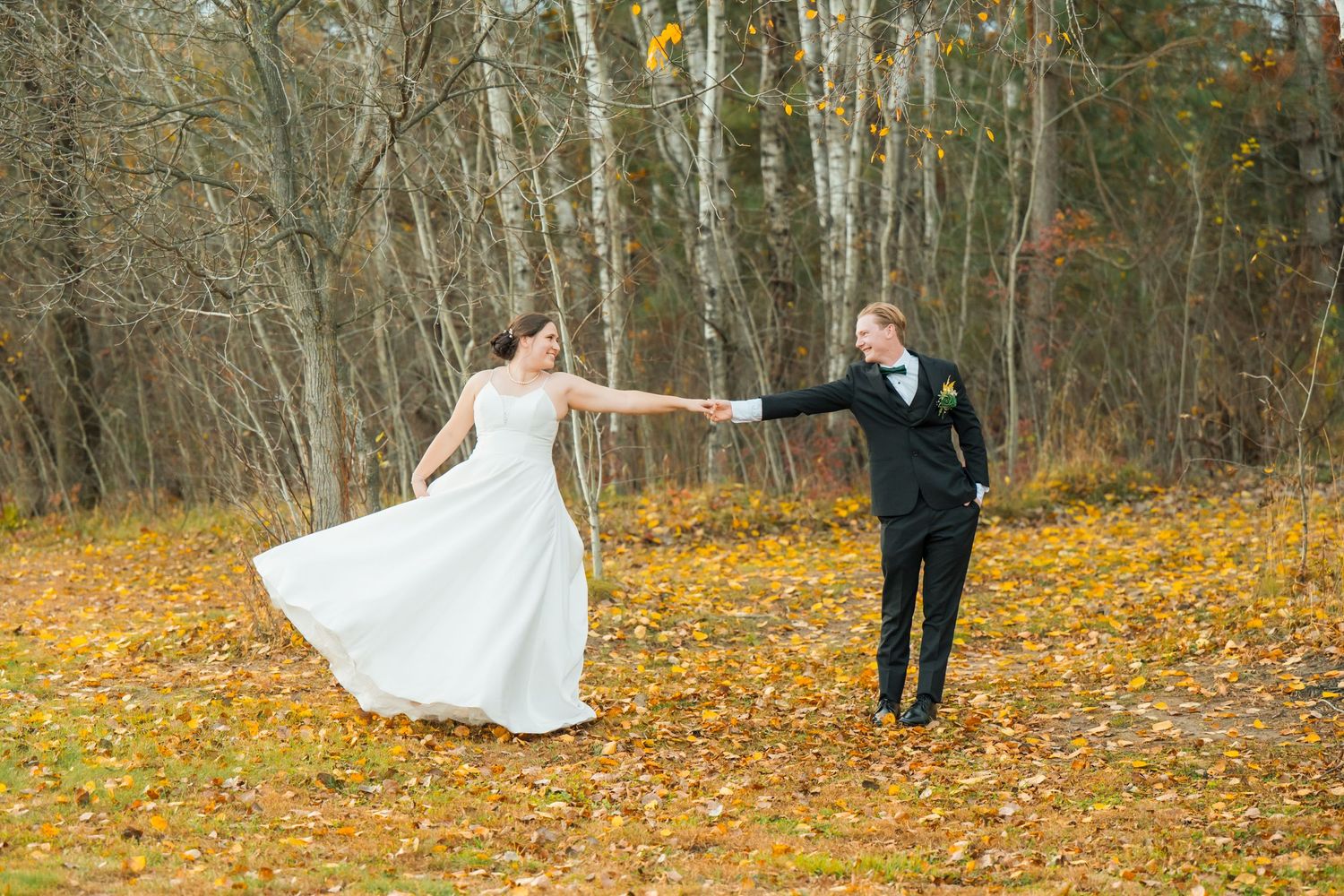 A couple dances together in a scenic fall setting with birch trees and golden leaves.