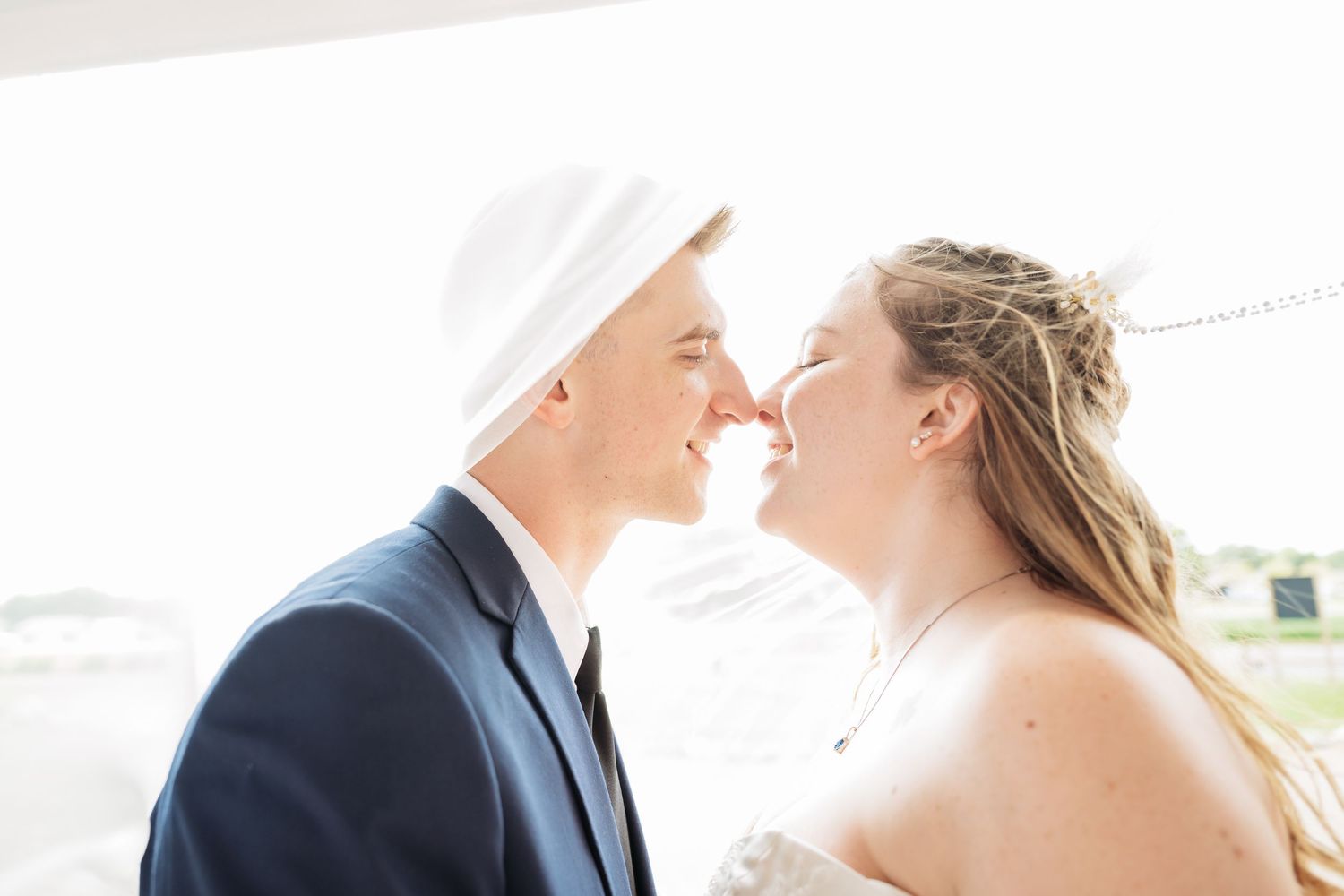 Newlyweds embrace tenderly during an outdoor wedding photoshoot with soft natural lighting at Northern Lights near Milaca MN..