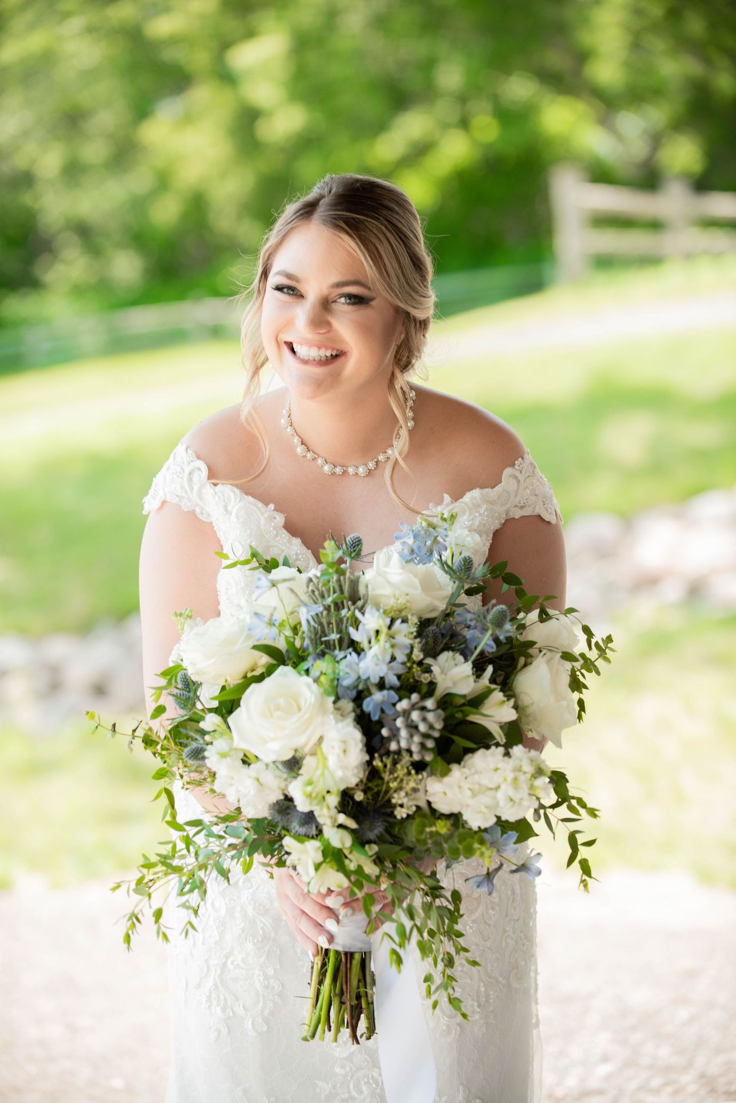 Beautiful wedding bouquet with white roses and blue accents complementing a lace bridal gown. Zimmerman MN Weddings