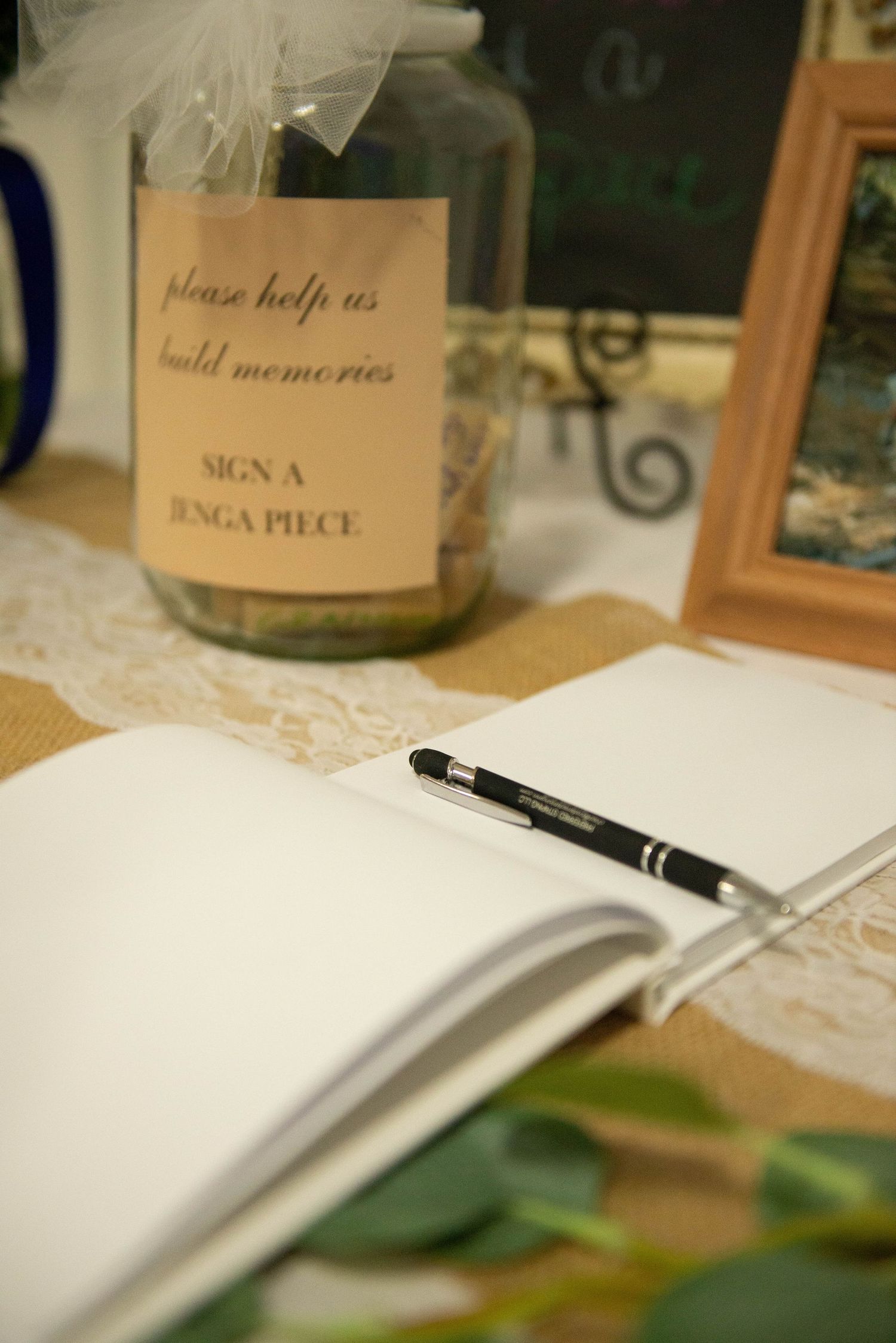 Wedding guest book with pen and decorative signs on display. Zimmerman MN Weddings