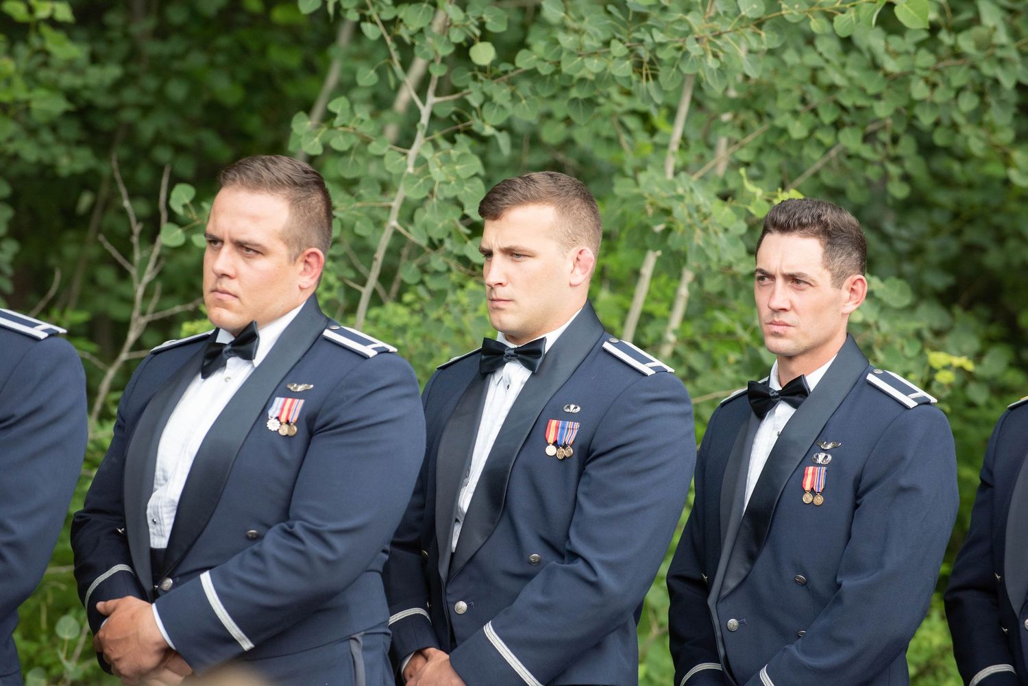 Groomsmen in dark military uniforms standing in line during outdoor wedding ceremony. Zimmerman MN Weddings