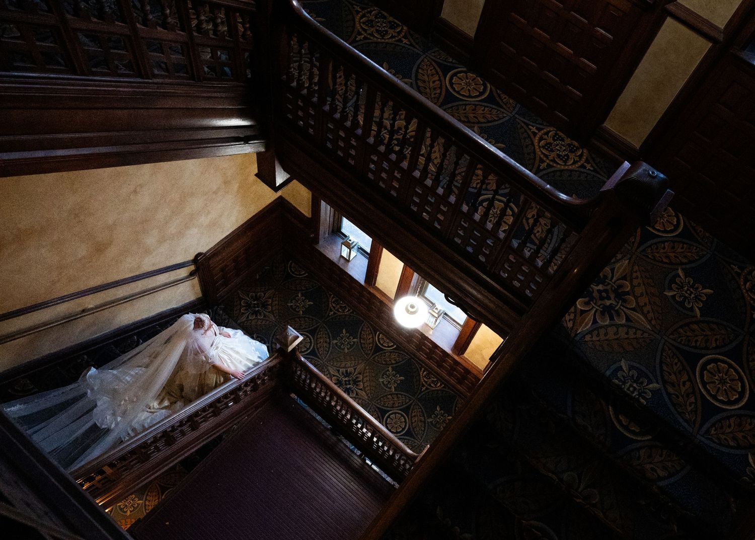 Wedding at The Historic Concord Exchange Minneapolis MN. ornate wooden staircase with patterned carpet and decorative balusters.